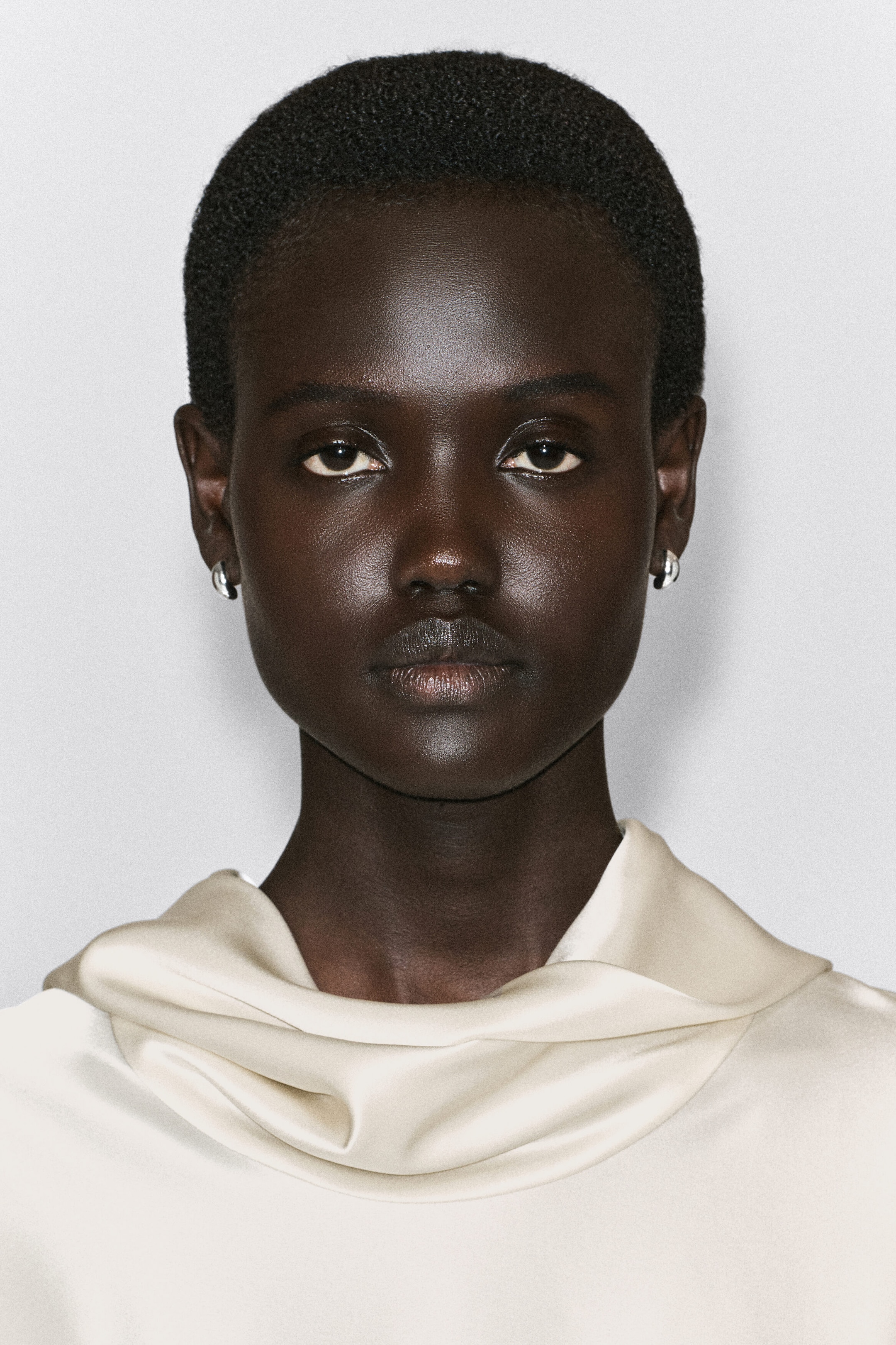 Des boucles d’oreilles demi-créoles sculpturales à finition argent polie sont portées par une mannequin de face afin d’en montrer l’échelle et l’ajustement. Les boucles d’oreilles présentent un design bombé, courbé et massif qui épouse de près les lobes d’oreilles. Des boucles d’oreilles demi-créoles sculpturales à finition argent polie sont portées par une mannequin de face afin d’en montrer l’échelle et l’ajustement. Les boucles d’oreilles présentent un design bombé, courbé et massif qui épouse de près les lobes d’oreilles.