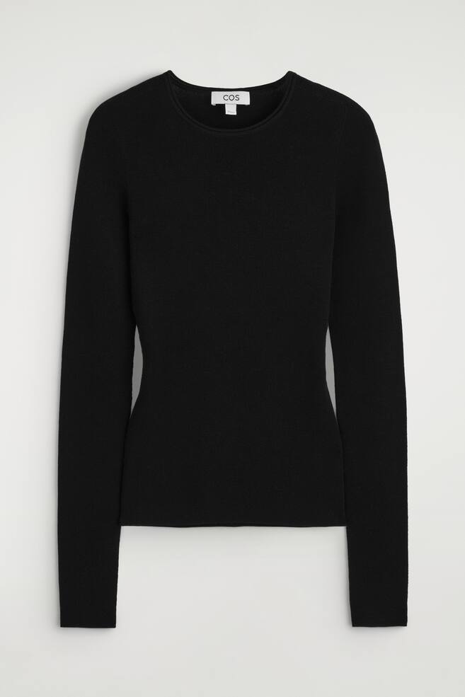 Uma camisola preta de manga comprida é apresentada de frente, apresentando um decote redondo tubular, uma textura ligeiramente canelada em toda a peça, um corte justo e uma bainha direita. - 1
