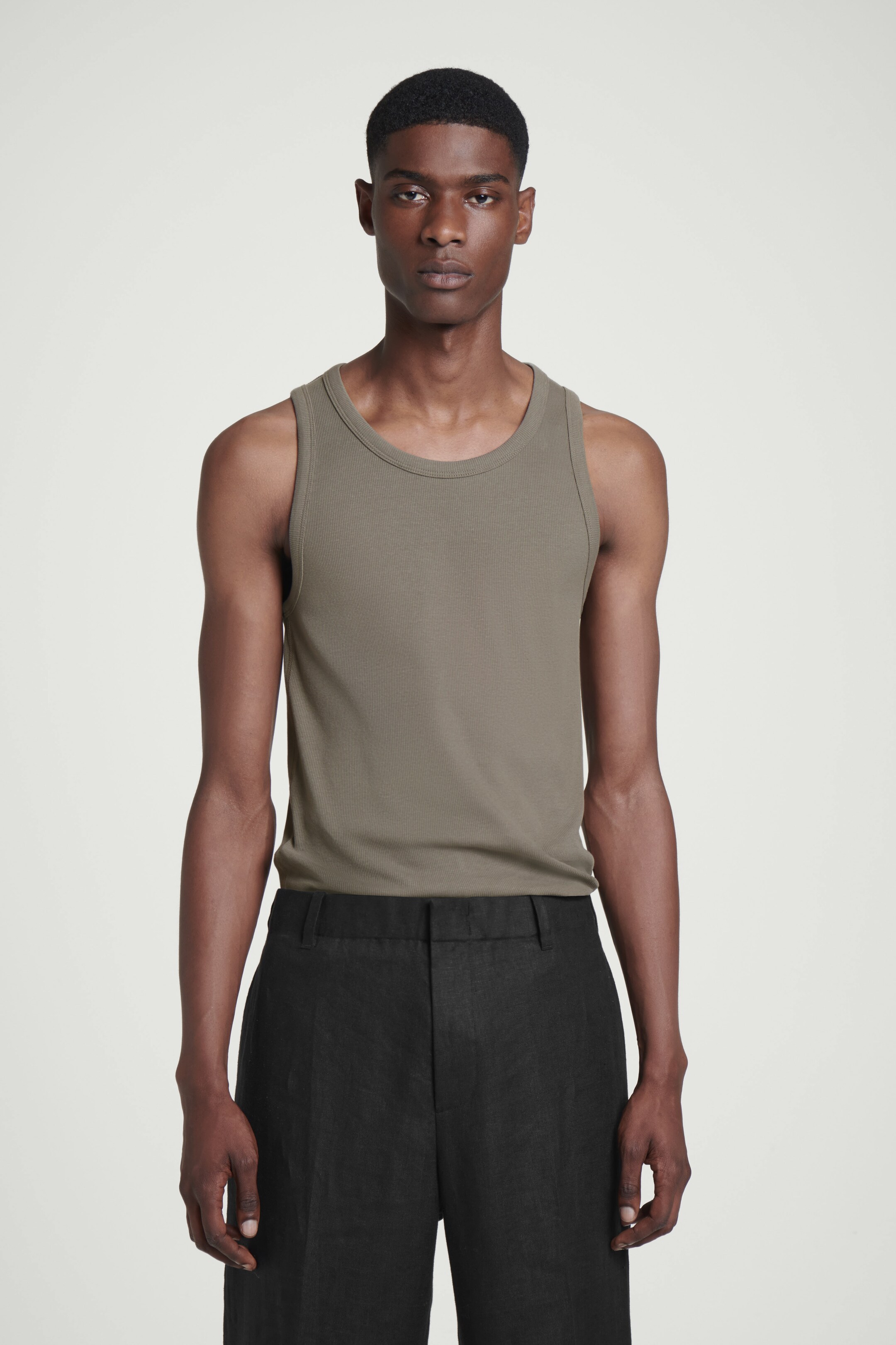 Zobrazit větší obrázek: ÚZKÝ ŽEBROVANÝ BAVLNĚNÝ TÍLKO - TMAVÁ KRTKOVÁ - MUŽI | H&M CZ 1