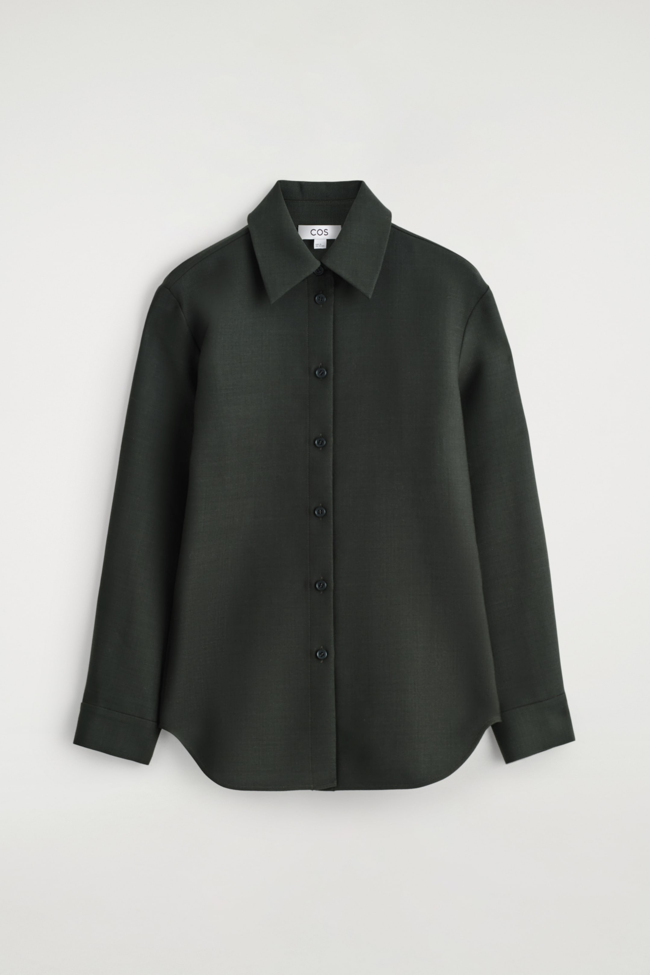 Agrandir l'image: Une chemise en laine décontractée est positionnée face à l'avant, affichant une couleur vert foncé et un col évasé. Elle est conçue avec une patte de boutonnage pleine longueur avec des boutons ton sur ton, des manches longues avec des poignets à bouton unique, et un ourlet subtilement incurvé.