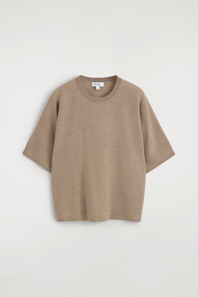 Un tricou tricotat de culoare maro deschis își prezintă partea din față, având un decolteu rotund cu nervuri și o etichetă COS vizibilă. Prezintă o textură fină de tricot și mâneci scurte, având o croială lejeră. - 1