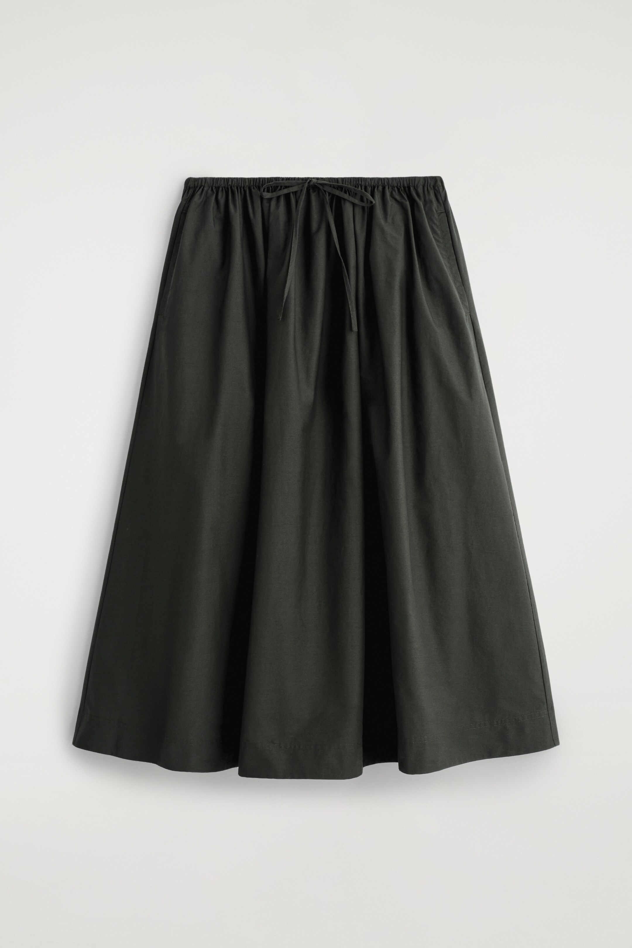 Agrandir l'image: Une jupe vert foncé est orientée vers l'avant, avec une taille élastiquée et un cordon de serrage au centre devant et deux poches latérales. Elle présente une silhouette évasée en A avec des plis naturels, atteignant une longueur mi-mollet.