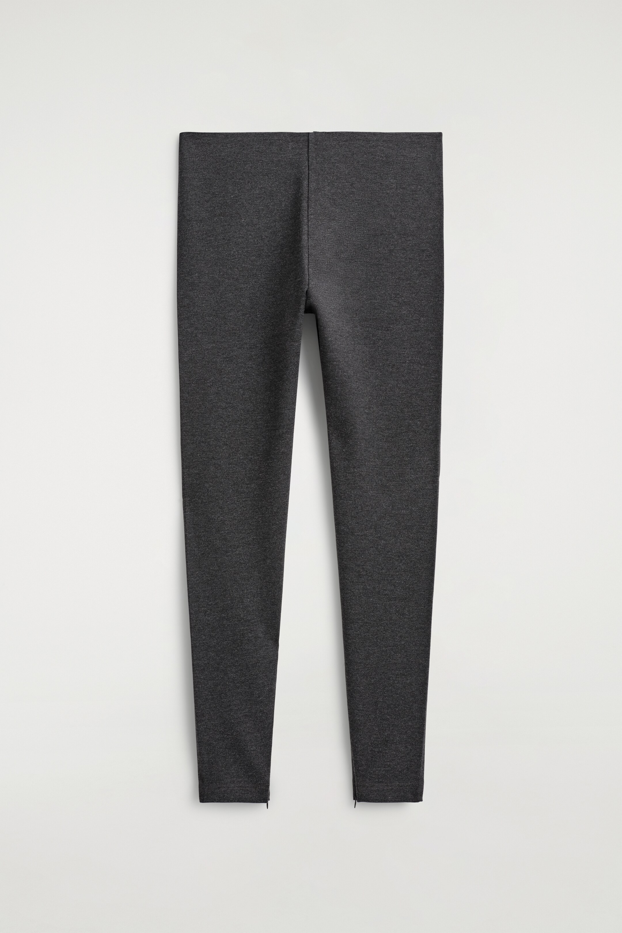 Grotere afbeelding bekijken: ZIPPED-CUFF LEGGINGS worden plat getoond en zijn naar voren gericht. De donkergrijze, gemêleerde leggings hebben een gladde tailleband en subtiele ritsen die aan de buitenkant van elke enkelsluiting open gaan.