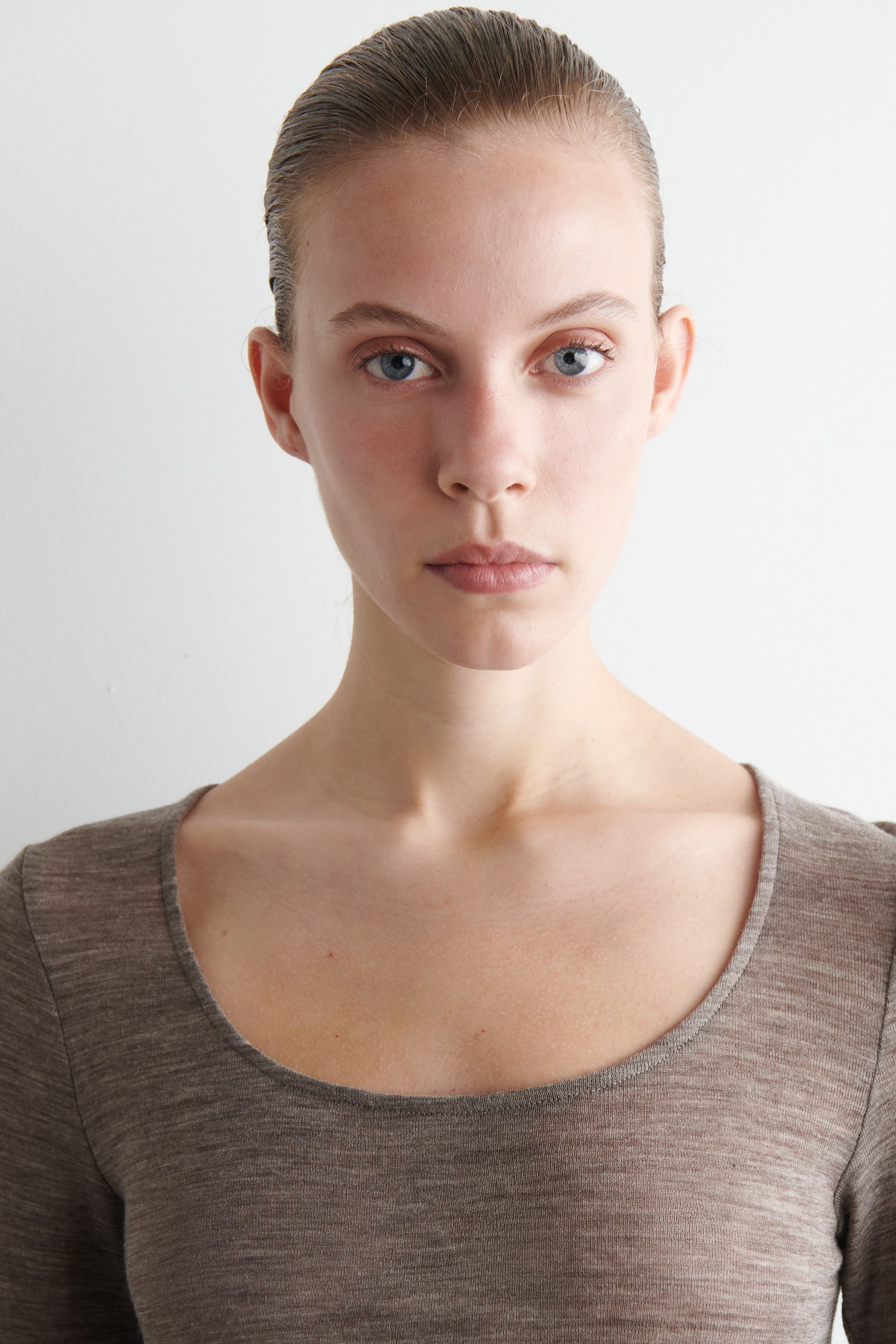 View larger image: A close-fitting, long-sleeved top is being presented front-on. It is featuring a wide scoop neckline and a heathered taupe fabric.