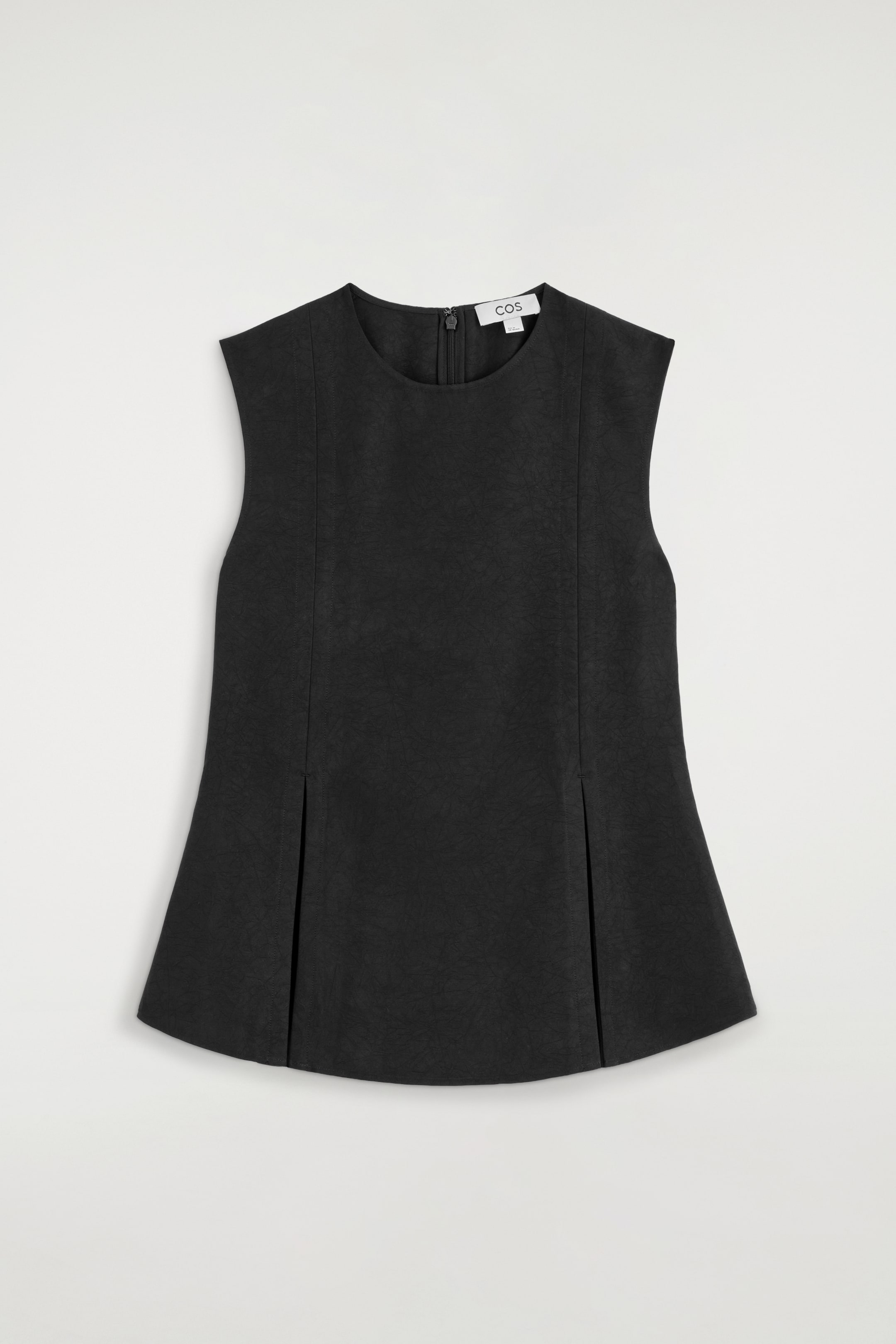 Visualizza immagine più grande: Un top peplum nero plissettato è mostrato in vista frontale, con scollo rotondo, spalle senza maniche dalla struttura definita e tessuto dalla texture materica. Le cuciture verticali che scendono lungo il davanti si aprono in profonde pieghe vicino all’orlo, creando una silhouette strutturata e svasata.