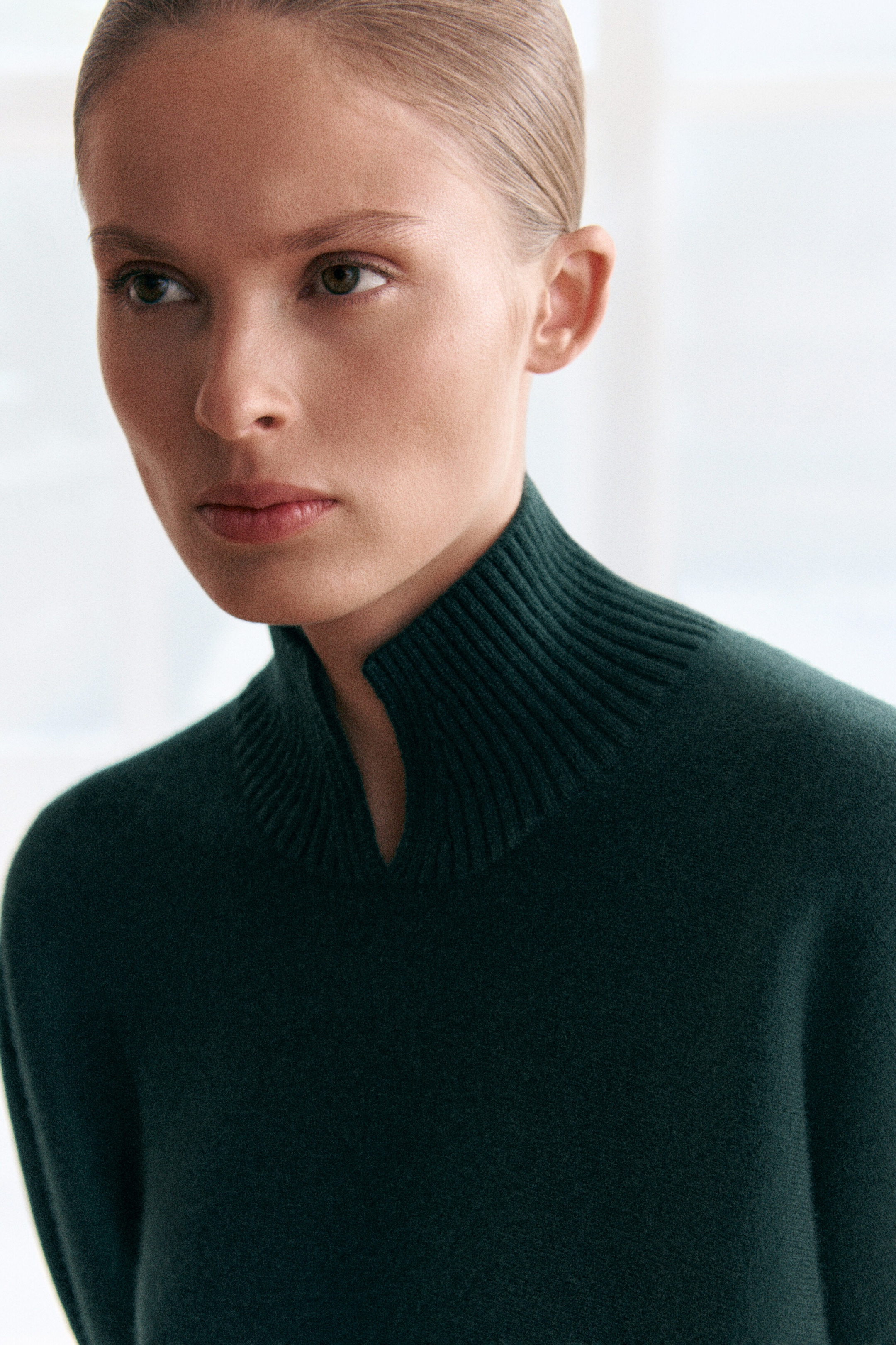 Ce chandail en laine bouillie vert foncé présente un col montant côtelé avec une découpe en V distinctive à l’avant, mettant en valeur sa texture tricotée douce et dense. Ce chandail en laine bouillie vert foncé présente un col montant côtelé avec une découpe en V distinctive à l’avant, mettant en valeur sa texture tricotée douce et dense.