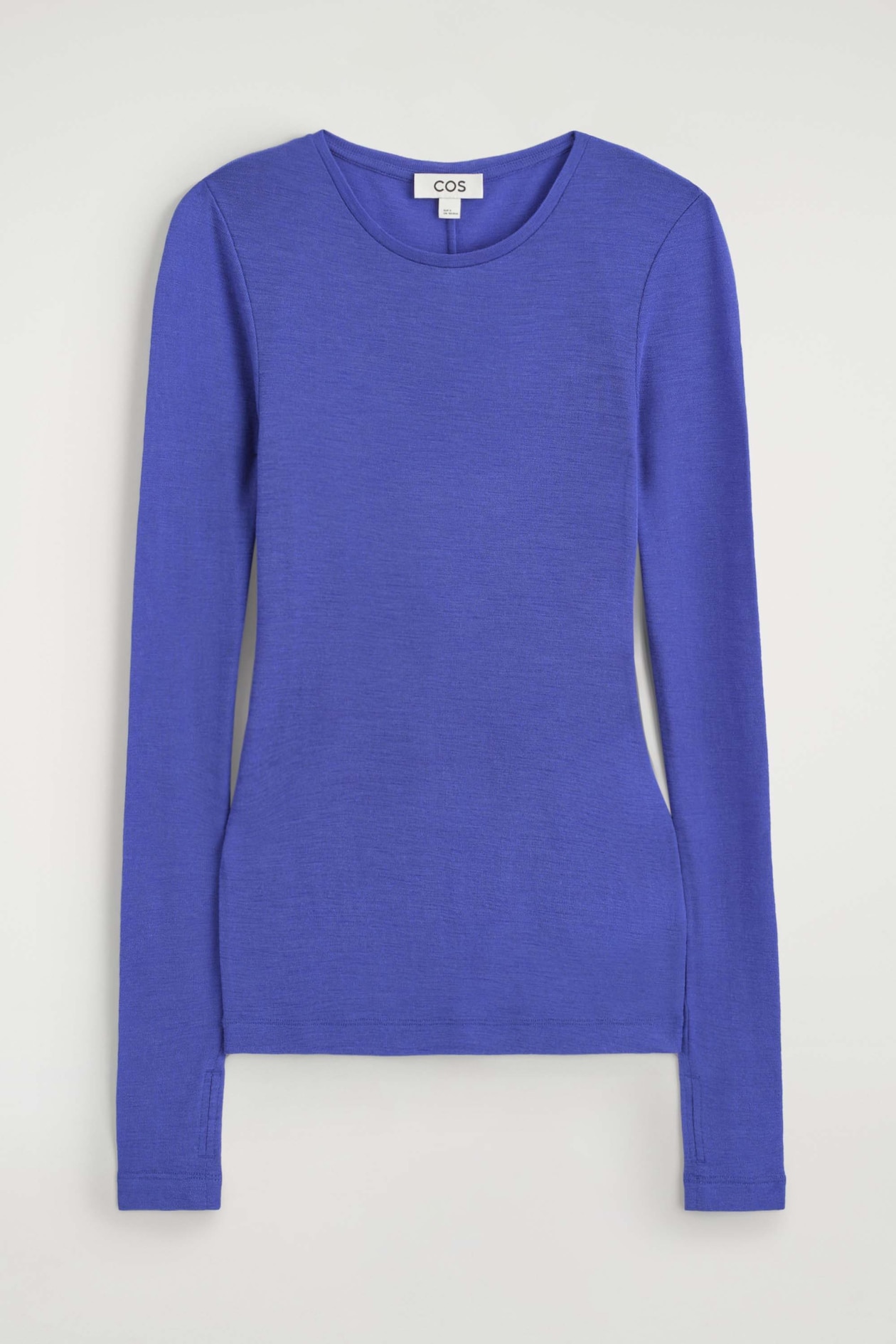 The slim merino wool top is shown from the front in a vibrant blue colour, featuring a crew neck and a fitted silhouette. The long sleeves display subtle slit detailing at the cuffs.