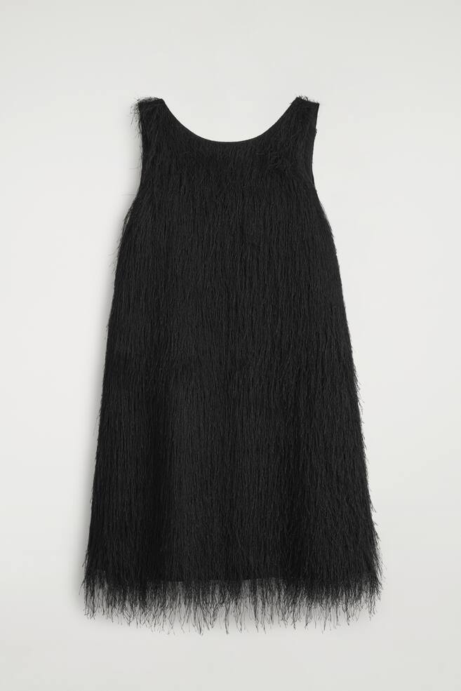 A black fringed mini dress is shown front-facing, featuring a sleeveless design, a scoop neckline and an A-line silhouette. The entire garment is covered in dense, fine-thread fringe that hangs vertically and extends beyond the hem. - 1