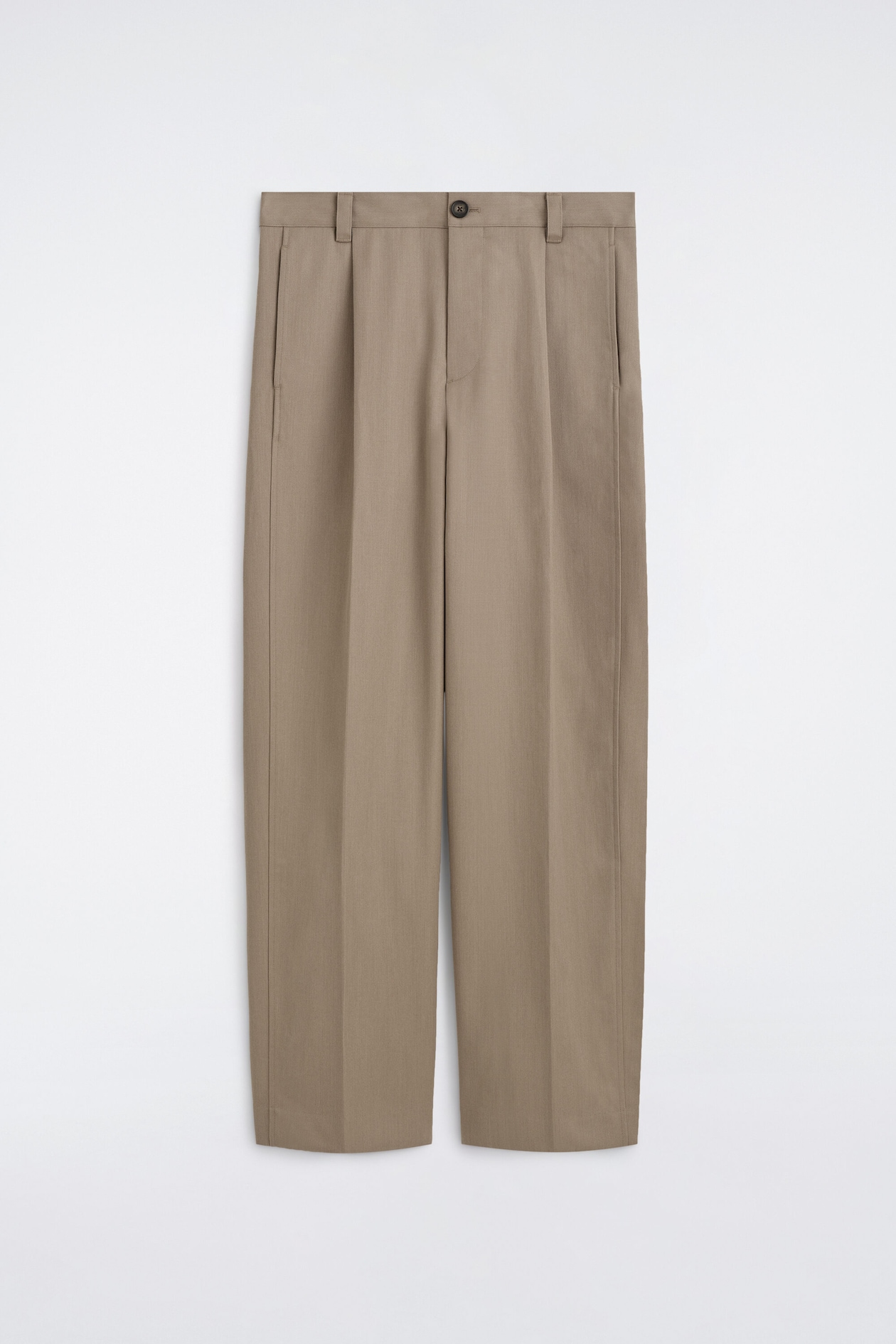 Estos pantalones plisados de color topo se presentan de frente, con una cinturilla estructurada con trabillas para cinturón, cierre de un solo botón y bolsillos laterales de abertura. Presentan marcadas líneas de planchado que recorren el centro de cada pierna recta, resaltando el corte entallado.