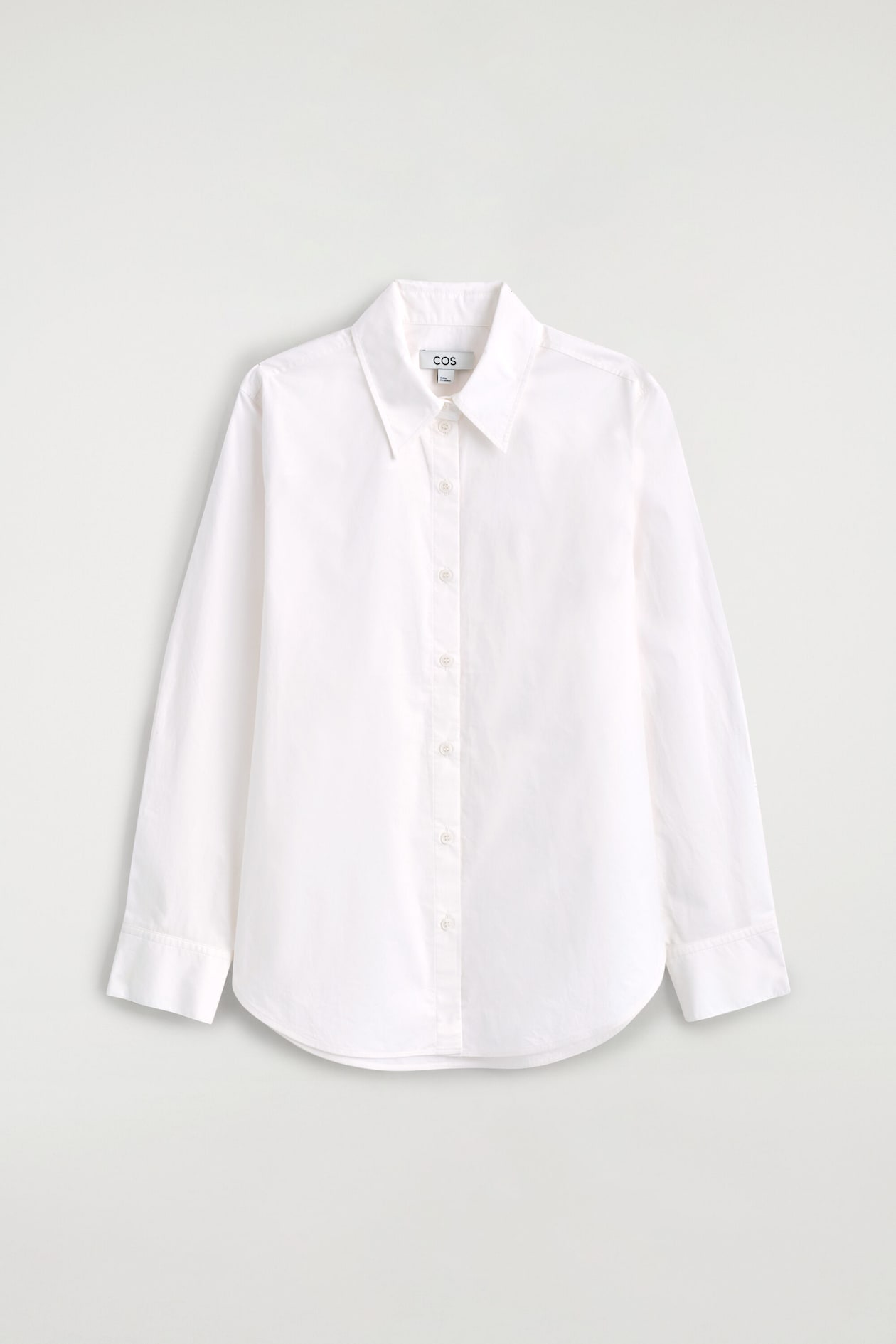 The classic cotton-poplin shirt is facing the front, displaying a pointed collar, a button-up front with tonal buttons, long sleeves with wide cuffs, and a curved hemline.