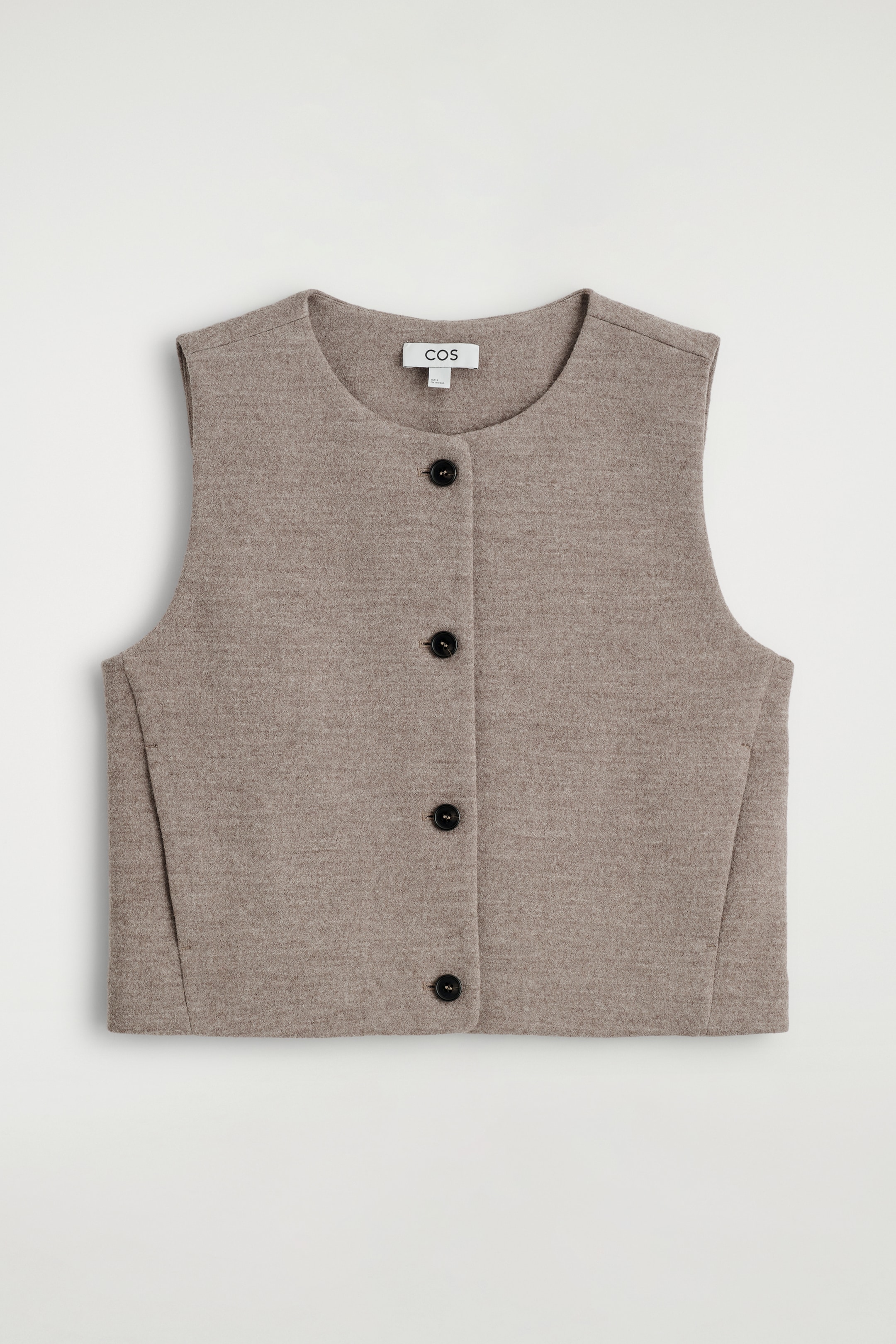 View larger image: A light brown sleeveless waistcoat is presented FRONT, lying flat, featuring a rounded neckline and a front button closure with four black buttons. Angular seams are visible on the front panels, contributing to its structured shape.