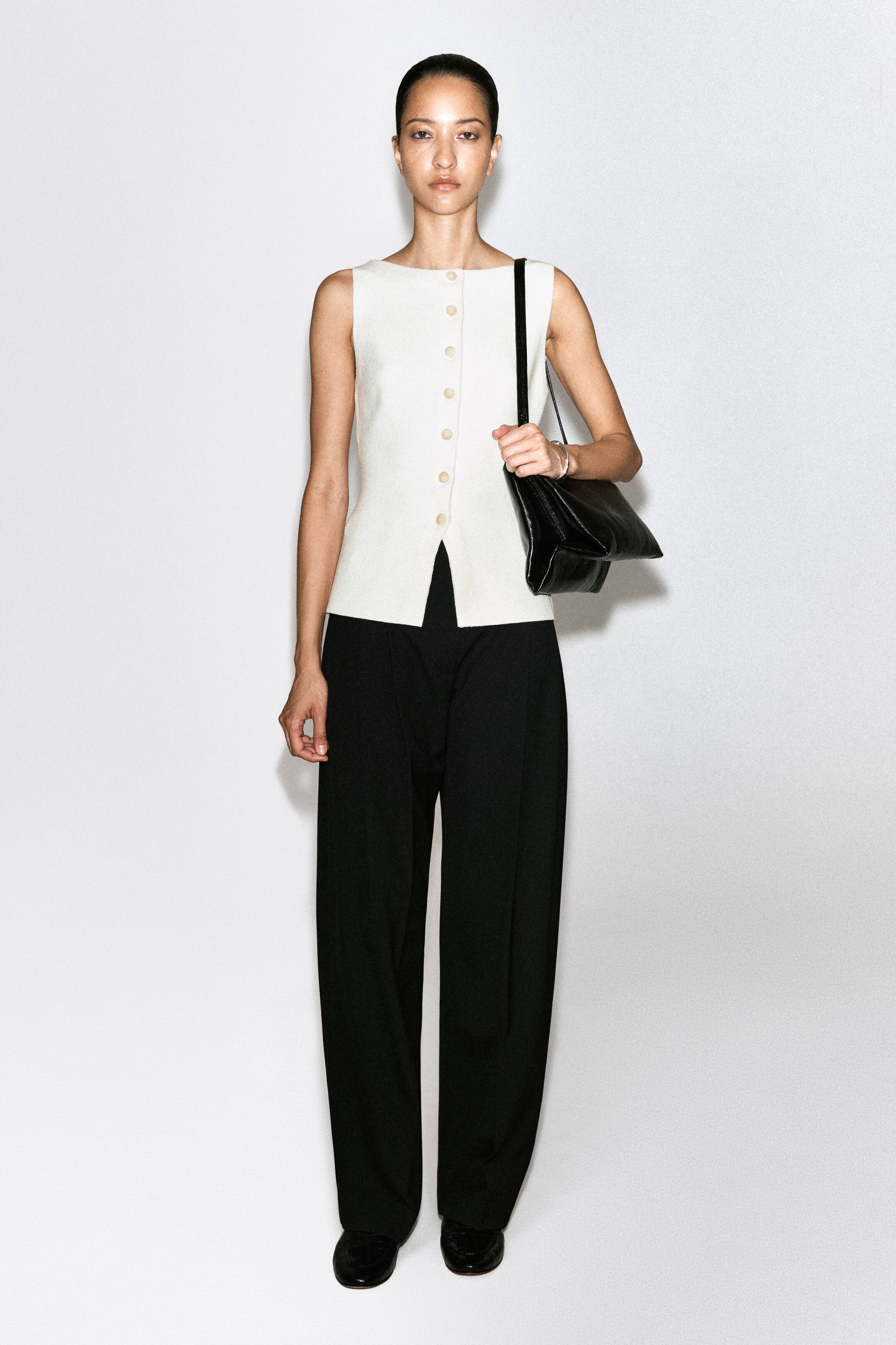 View larger image: An off-white sleeveless waistcoat is shown from the front, showcasing a slim, streamlined silhouette and textured fabric. It features a round neckline, a full front button fastening with light-coloured buttons, and a subtle V-split at the front hem.