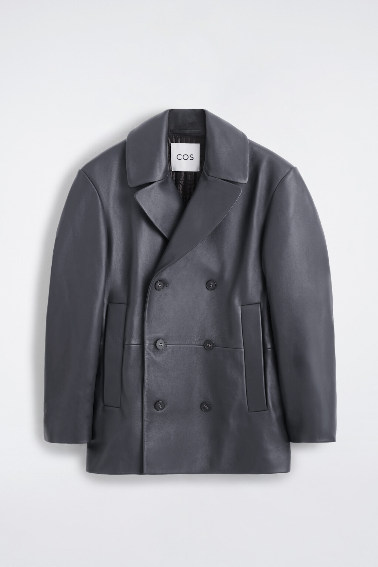 Ein dunkelgrauer, zweireihiger Peacoat aus Leder ist von vorne zu sehen und präsentiert breite fallende Revers, einen Sechs-Knopf-Verschluss und senkrechte Paspeltaschen. Die Jacke zeigt eine strukturierte Passform mit glatter Oberfläche und ein gestepptes Innenfutter, das am Kragen sichtbar ist.