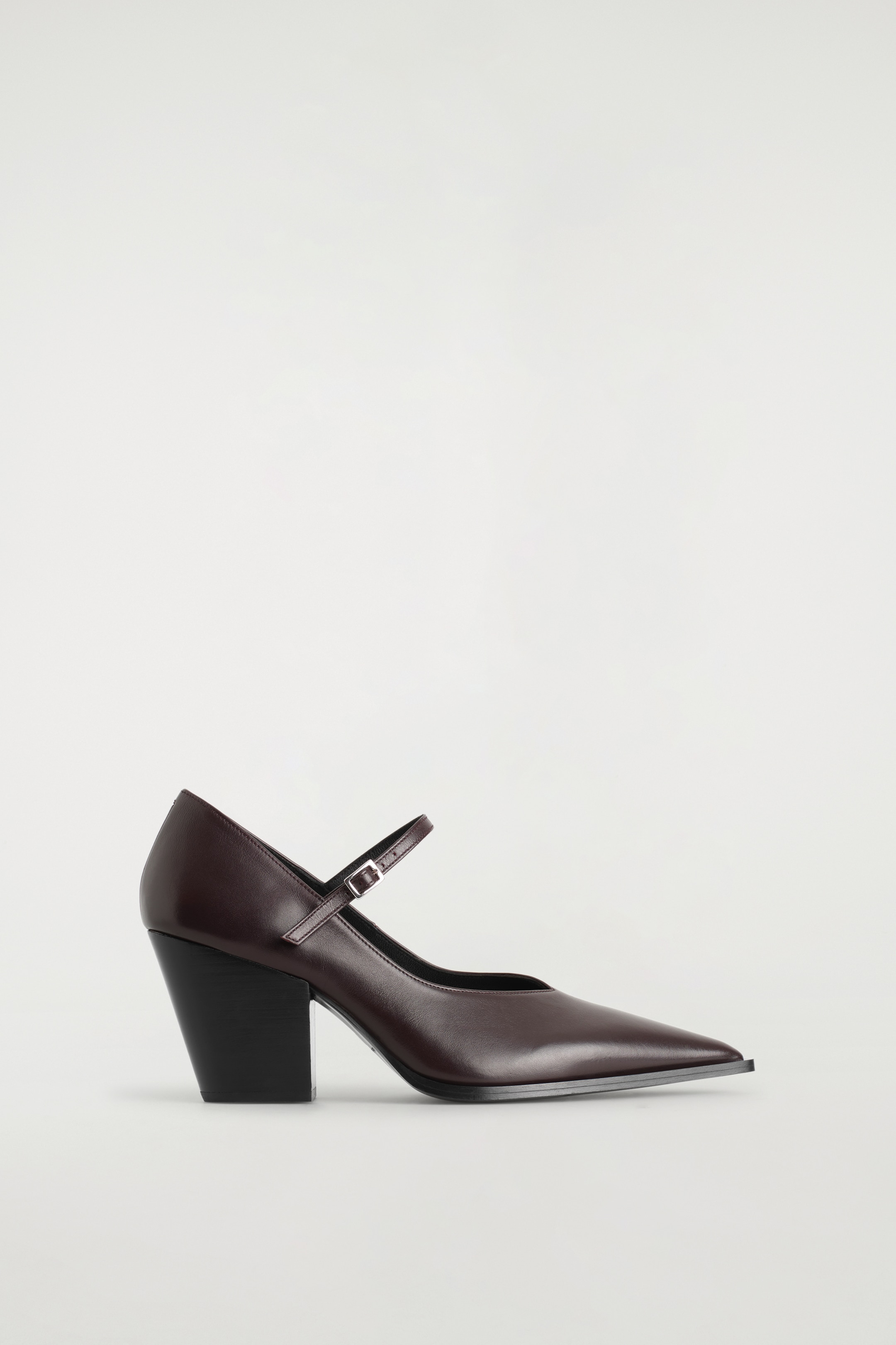 Agrandir l'image: Une chaussure Mary Jane en cuir marron foncé à talon est dotée d'un bout pointu, d'une seule bride avec une boucle argentée sur le cou-de-pied, et d'un talon bloc épais noir.