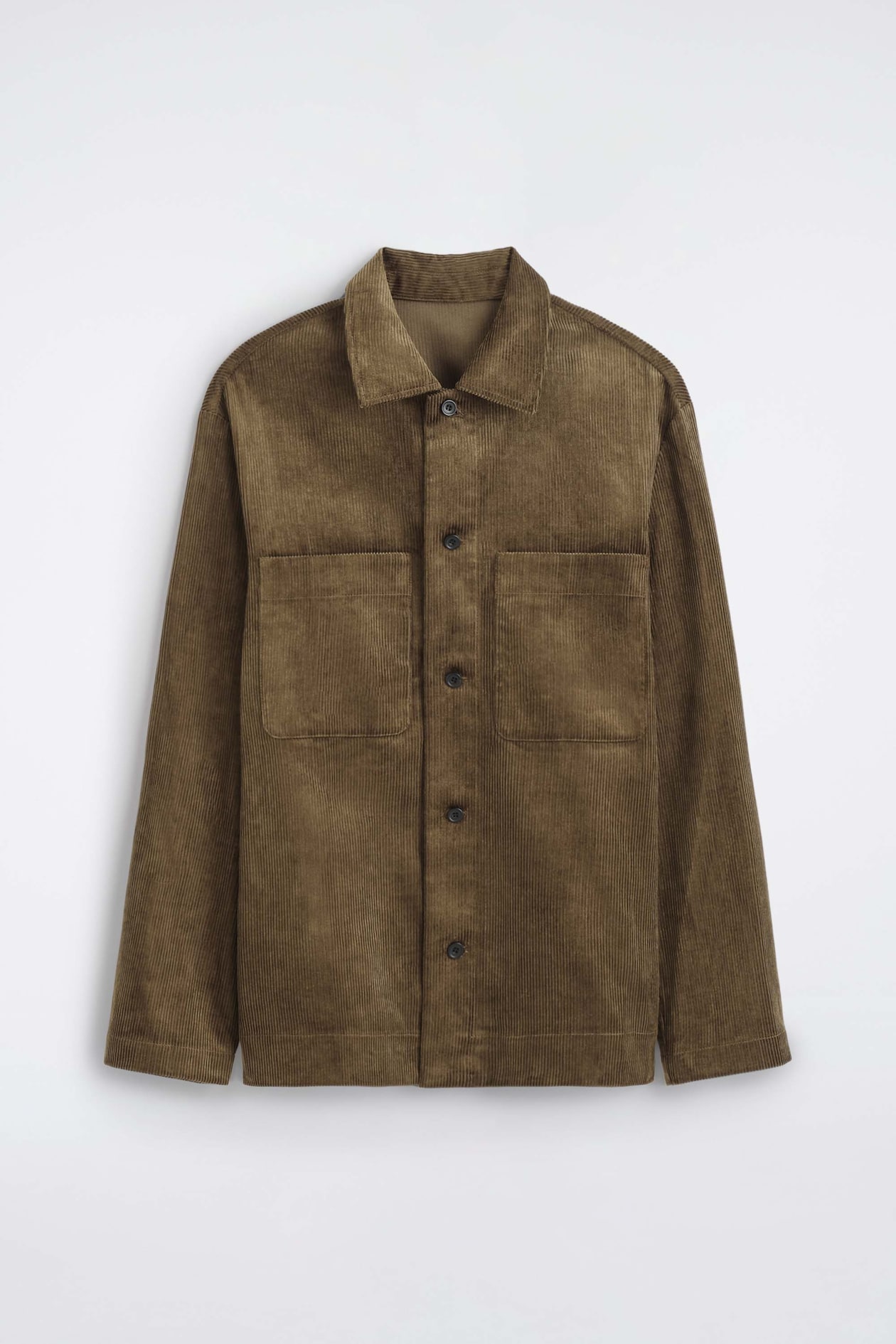 The cotton corduroy overshirt is shown front-facing, featuring a textured olive-brown ribbed fabric, a classic point collar and a button-up front fastening. It is designed with two large square patch pockets on the chest and long, straight-cut sleeves.