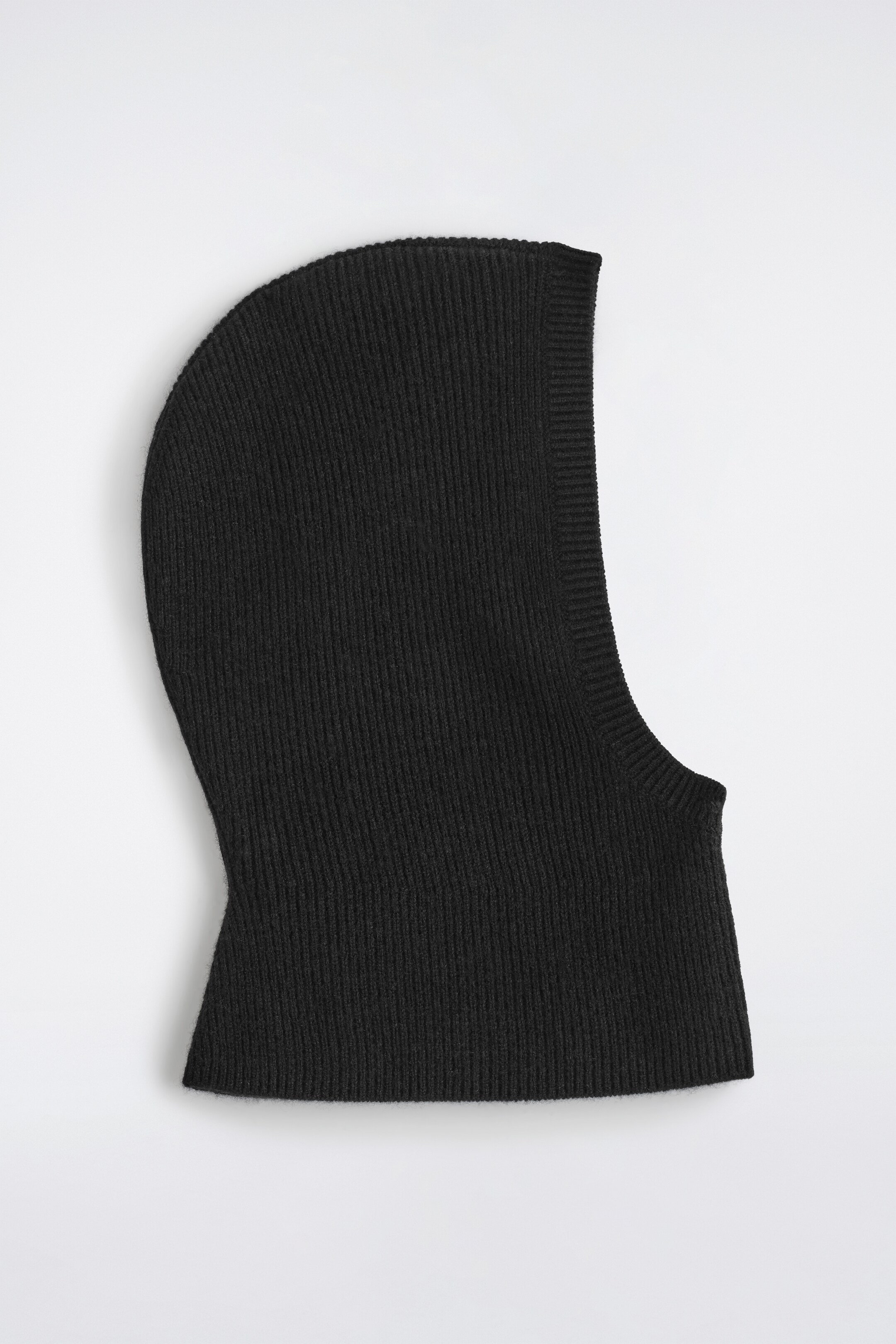 View larger image: A black, rib-knitted balaclava is shown FRONT, featuring a form-fitting design with a contoured opening for the face.
