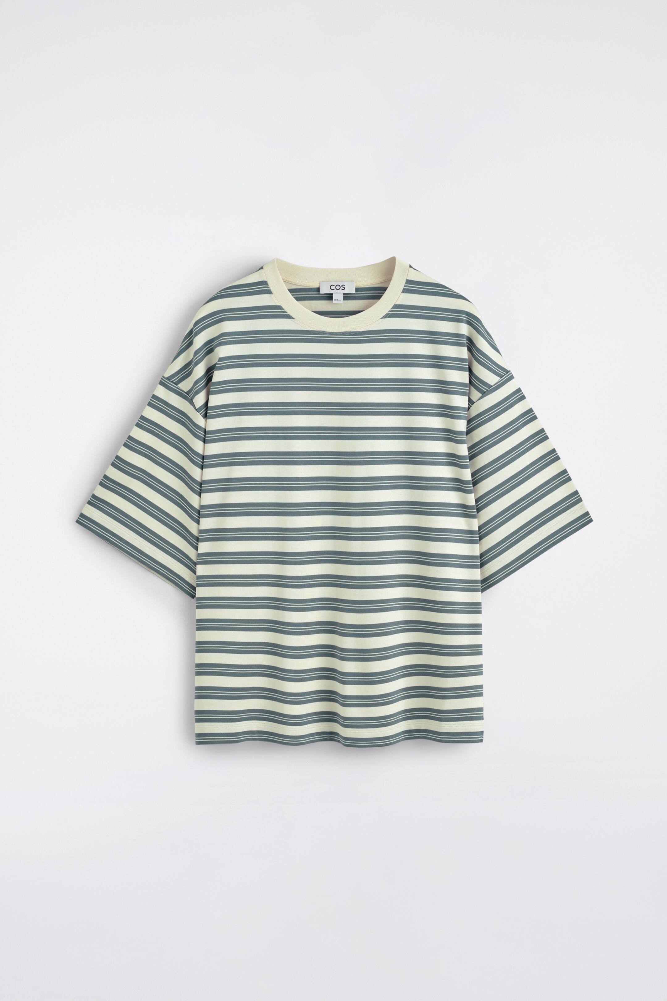 Größeres Bild anzeigen: Ein oversized T-Shirt mit Frontansicht ist mit blauen und cremeweißen horizontalen Streifen gemustert, ausgestattet mit einem cremeweißen gerippten Rundhalsausschnitt und kurzen, weiten Ärmeln.
