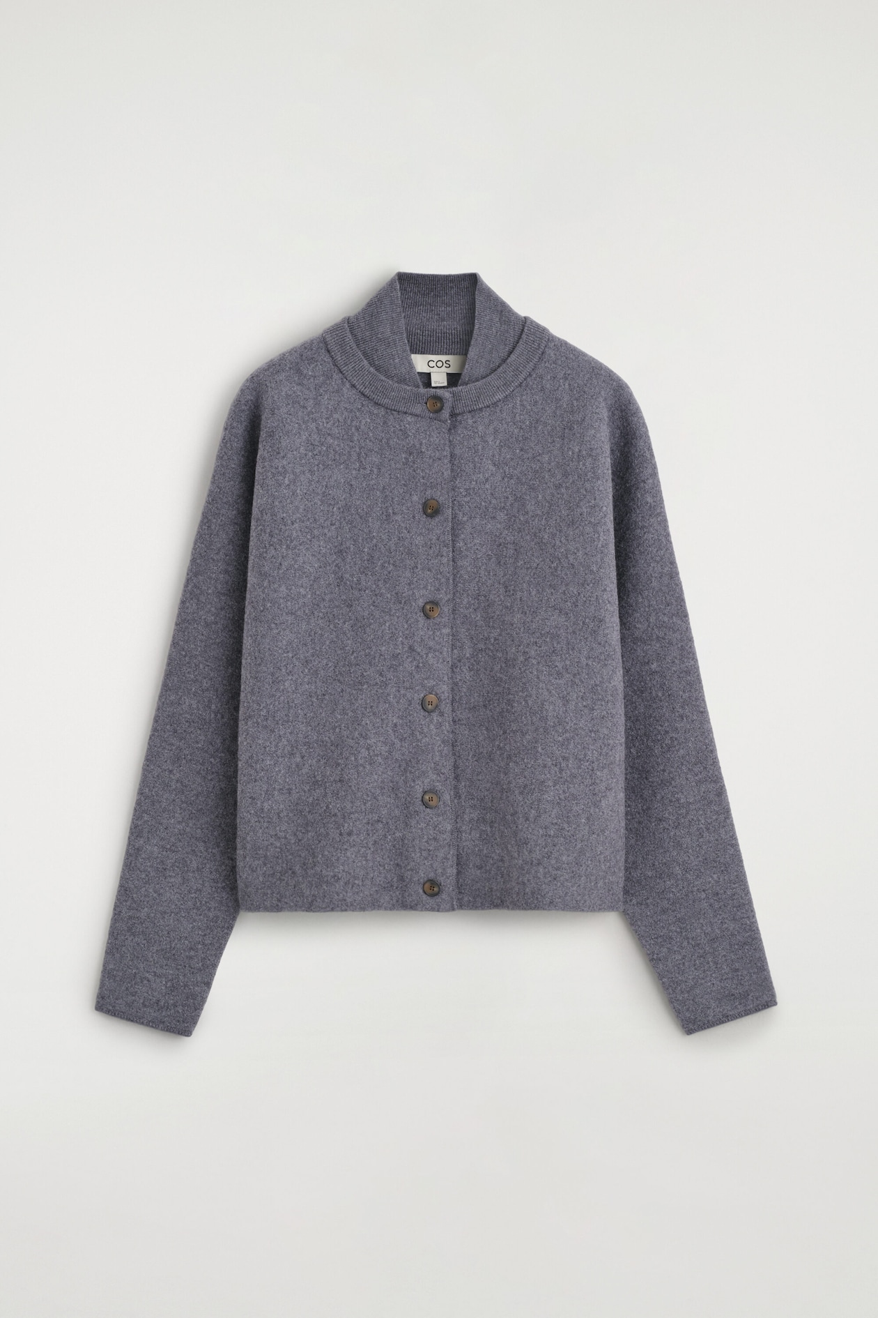 A gray boiled wool cardigan is shown from the front, showcasing a relaxed, boxy silhouette and a unique double-layered ribbed collar. The cardigan features a central button-front closure with six contrasting dark brown buttons and long, clean-finished sleeves.