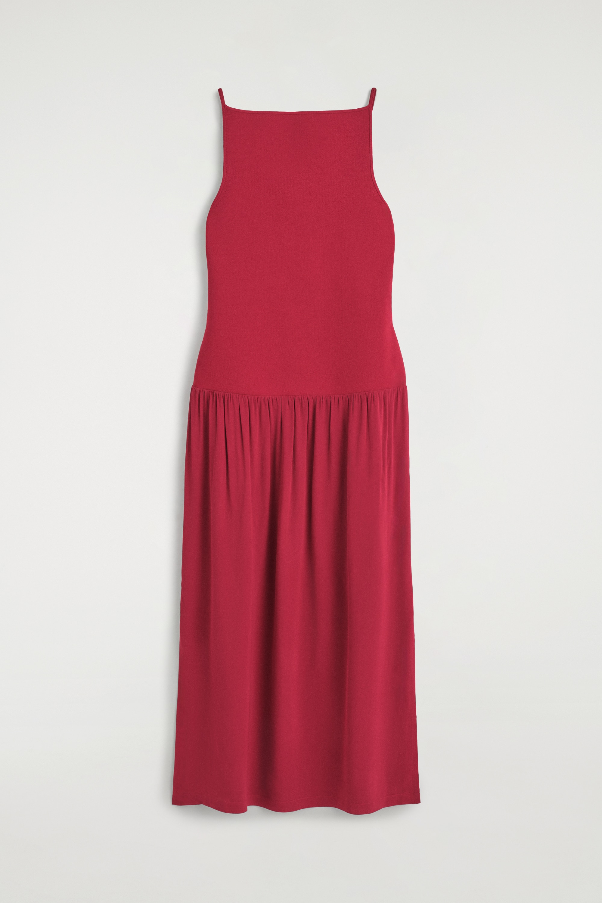 El vestido largo de paneles en contraste rojo se muestra de frente, poniendo de relieve un diseÃ±o sin mangas y un escote recto. El vestido presenta un cuerpo ajustado que, a partir de una cintura baja, da paso a una falda fluida y drapeada.