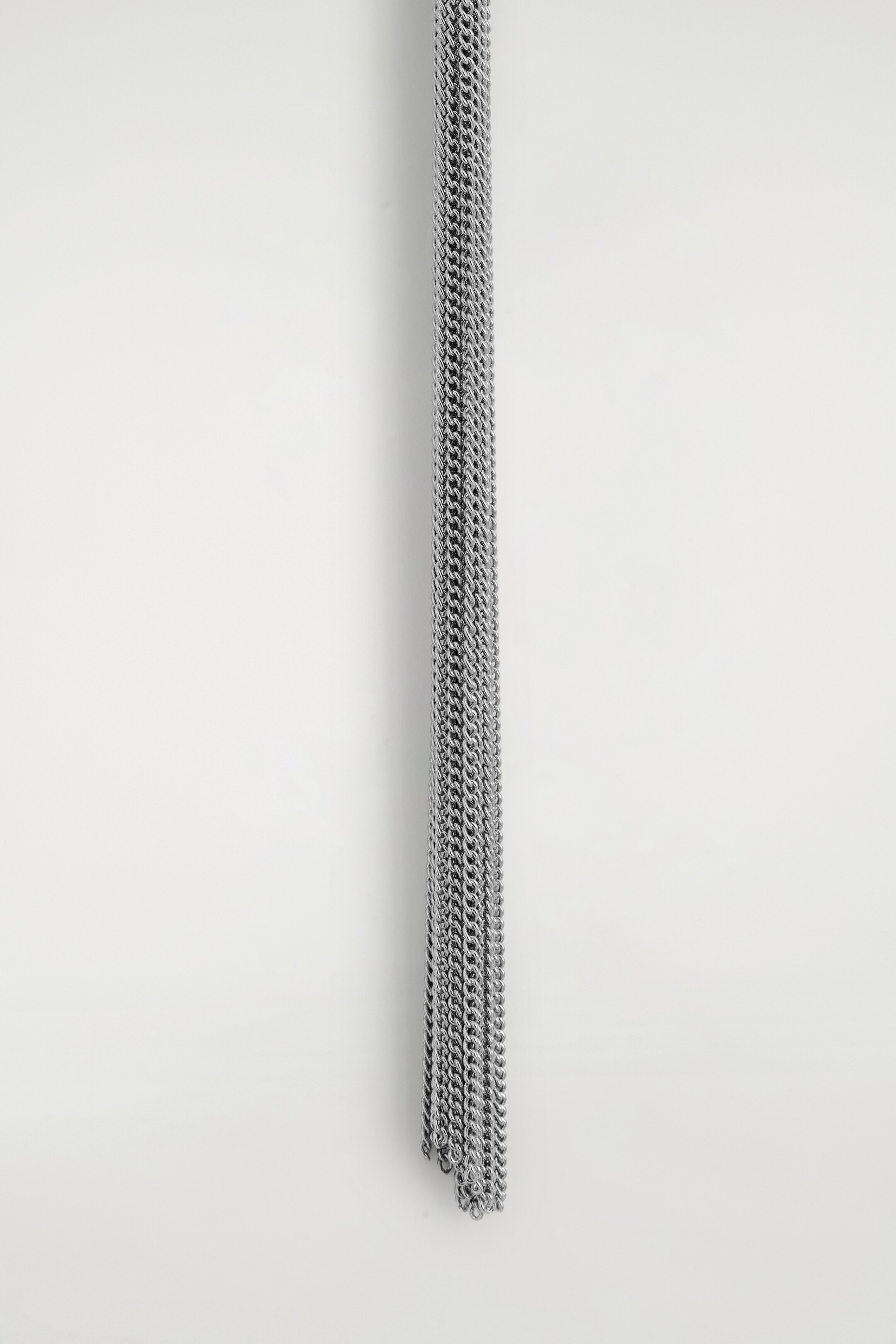 Ver imagen más grande: Una colección de cadenas de tono plateado cuelga verticalmente, formando una densa columna de pequeños eslabones interconectados.