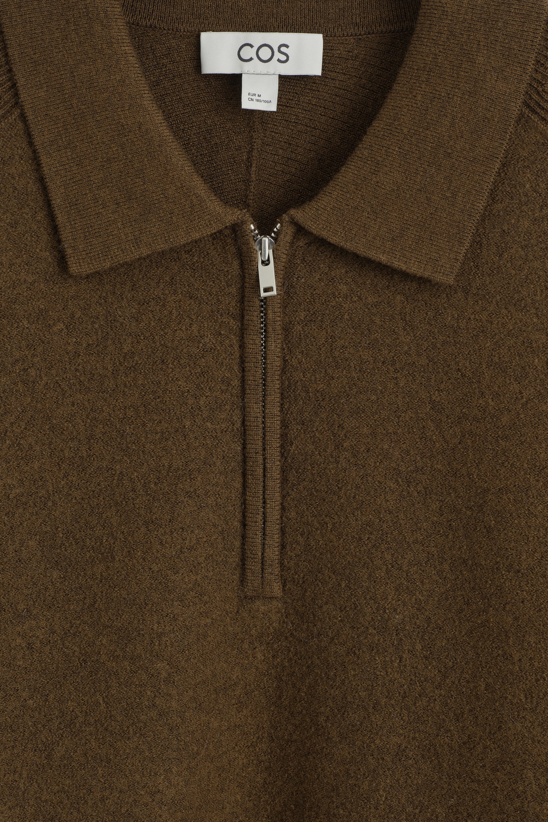 This close-up of the panelled boiled-wool zip-up jumper showcases its textured brown fabric, featuring a structured spread collar, a silver-tone metal half-zip fastening, and a white brand label at the inner neckline. This close-up of the panelled boiled-wool zip-up jumper showcases its textured brown fabric, featuring a structured spread collar, a silver-tone metal half-zip fastening, and a white brand label at the inner neckline.