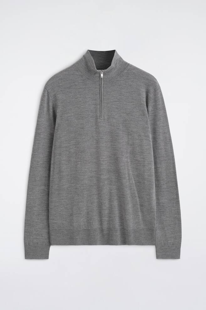 The grey merino wool zip-up funnel neck jumper is shown from the front, featuring a fine-knit texture. It has a high funnel collar with a silver-tone quarter-zip fastening, long sleeves with ribbed cuffs, and a ribbed hem. - 1