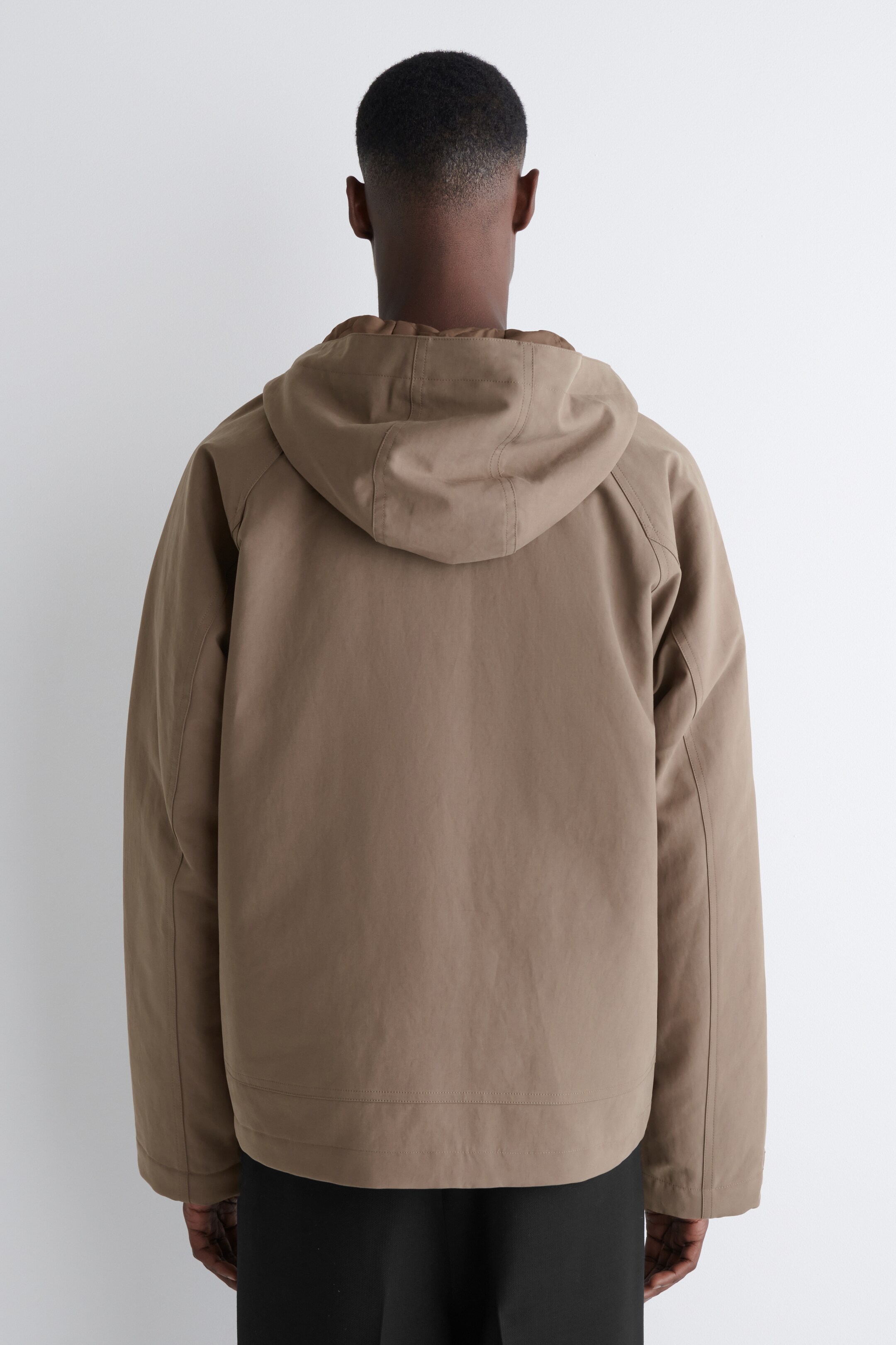 Visualizza immagine più grande: Una giacca color talpa viene presentata dal retro, con cappuccio e maniche raglan. Cuciture visibili dettagliano il cappuccio e le cuciture raglan. La giacca presenta una vestibilità rilassata e un orlo dritto.