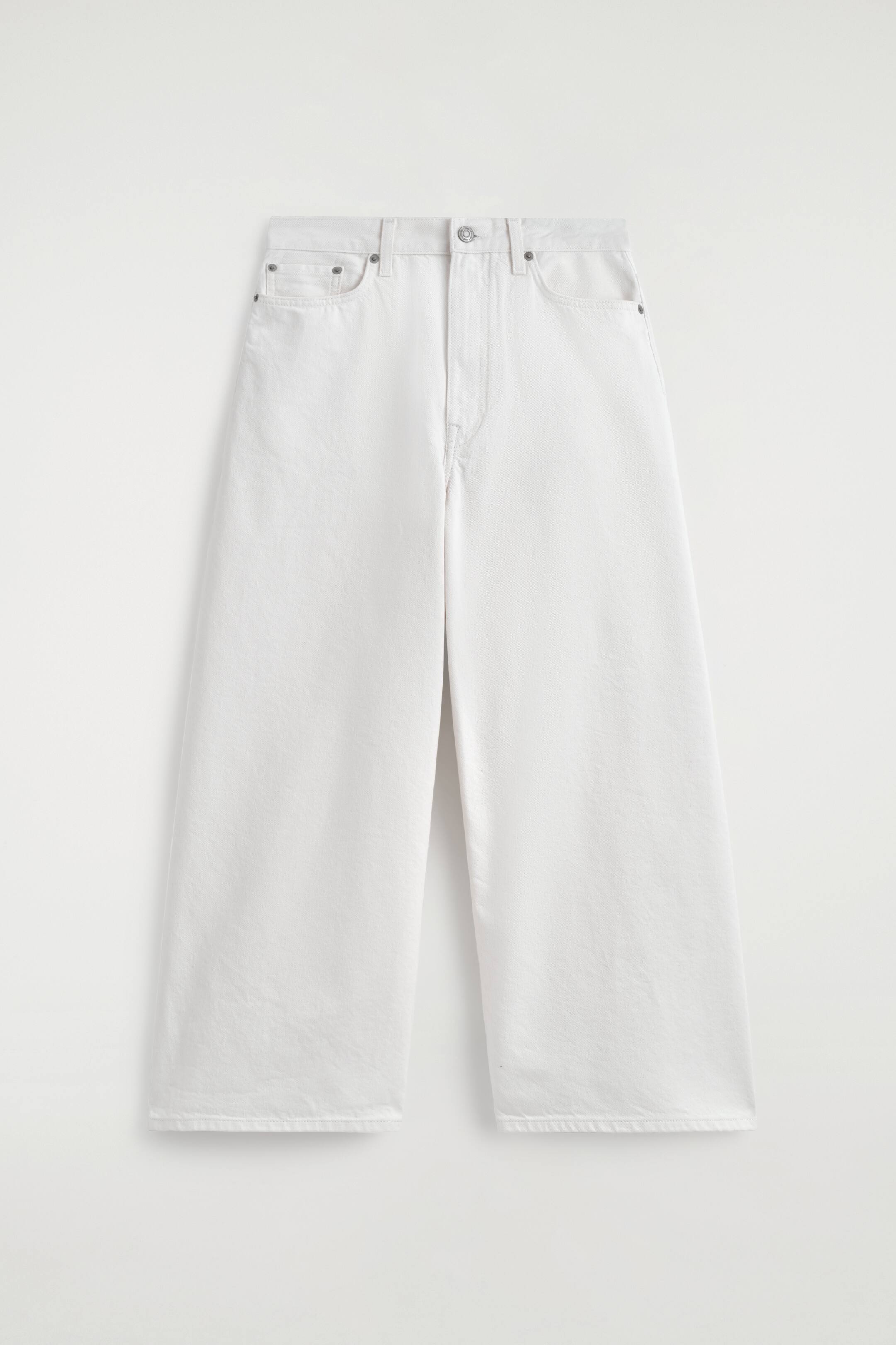 Agrandir l'image: Les culottes en denim blanc se présentent à plat de face, avec une coupe ample et décontractée. Elles affichent un design à cinq poches, comprenant deux poches fendues à l'avant, une poche à monnaie, ainsi qu'une fermeture à bouton et zip à la taille, le tout agrémenté de surpiqûres ton sur ton.