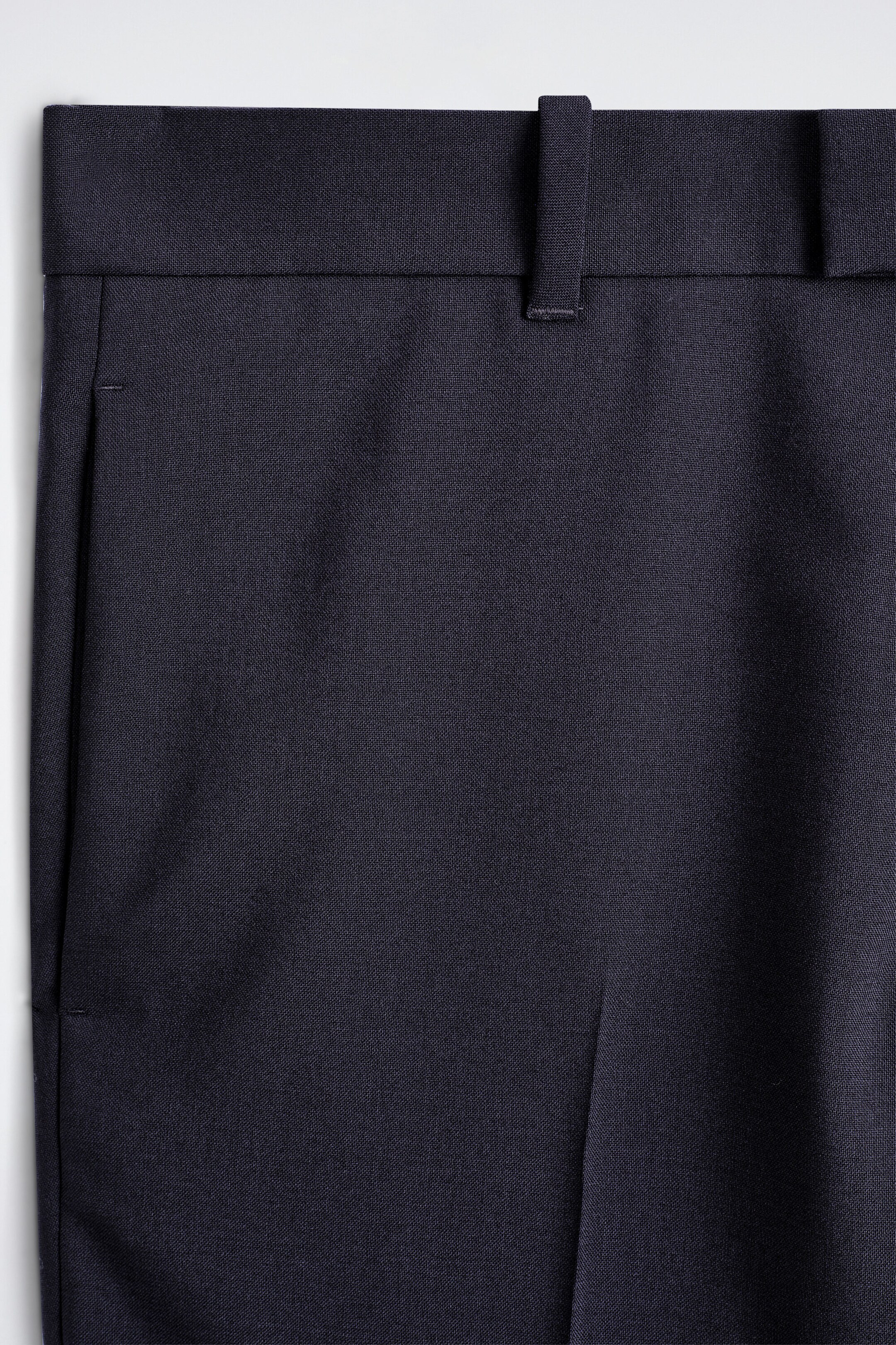 Un pantalon en laine à coupe slim et jambe droite est présenté en gros plan de face, mettant en valeur la fine texture tissée du tissu bleu marine foncé, une taille structurée avec passants de ceinture et une poche latérale ouverte. Un pantalon en laine à coupe slim et jambe droite est présenté en gros plan de face, mettant en valeur la fine texture tissée du tissu bleu marine foncé, une taille structurée avec passants de ceinture et une poche latérale ouverte.