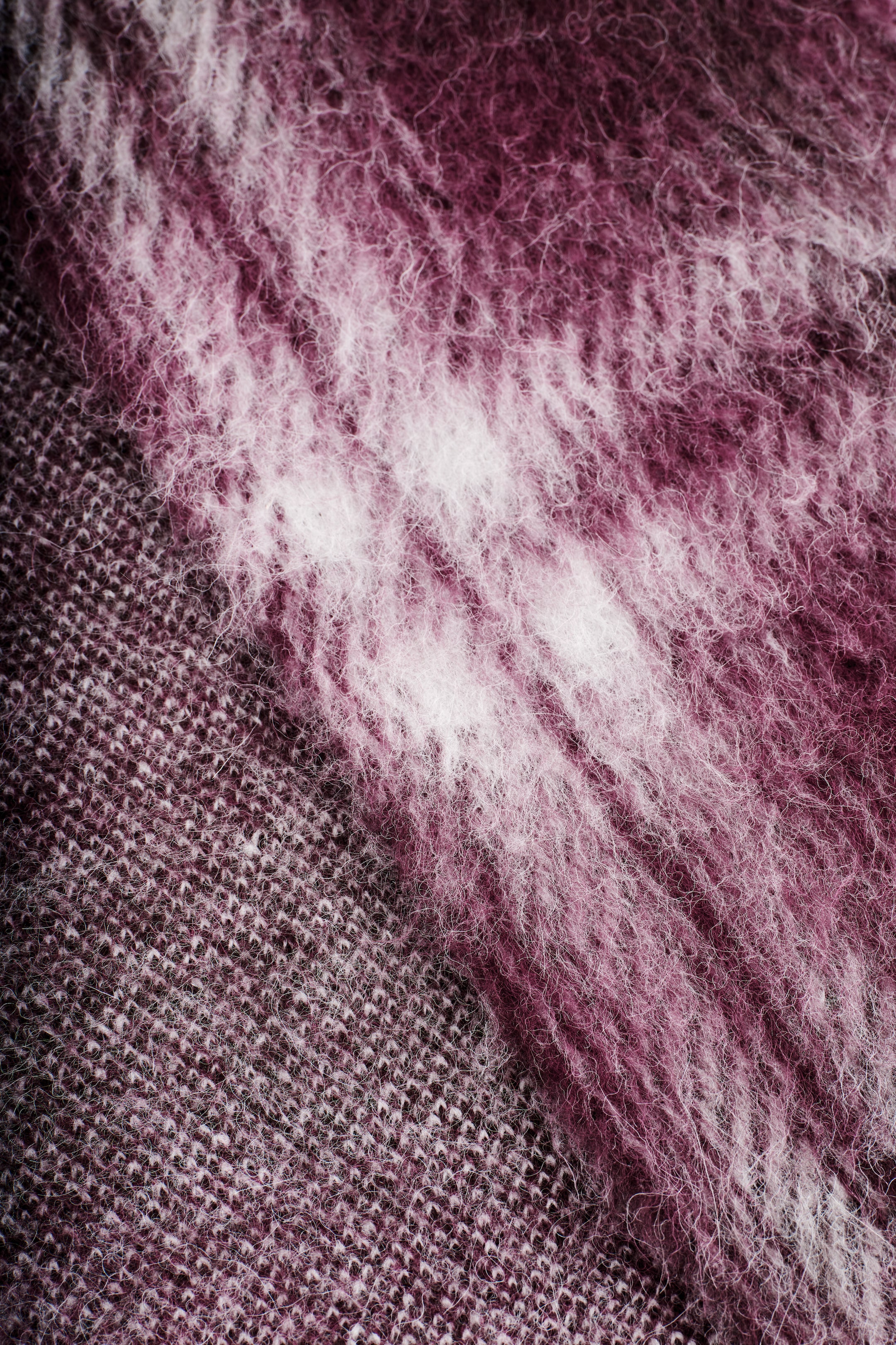 Agrandir l'image: Une écharpe présente une surface texturée et brossée avec un motif à carreaux dans des tons de marron et blanc. Une section de l'écharpe est également visible, arborant un tricot uni marron subtilement texturé.