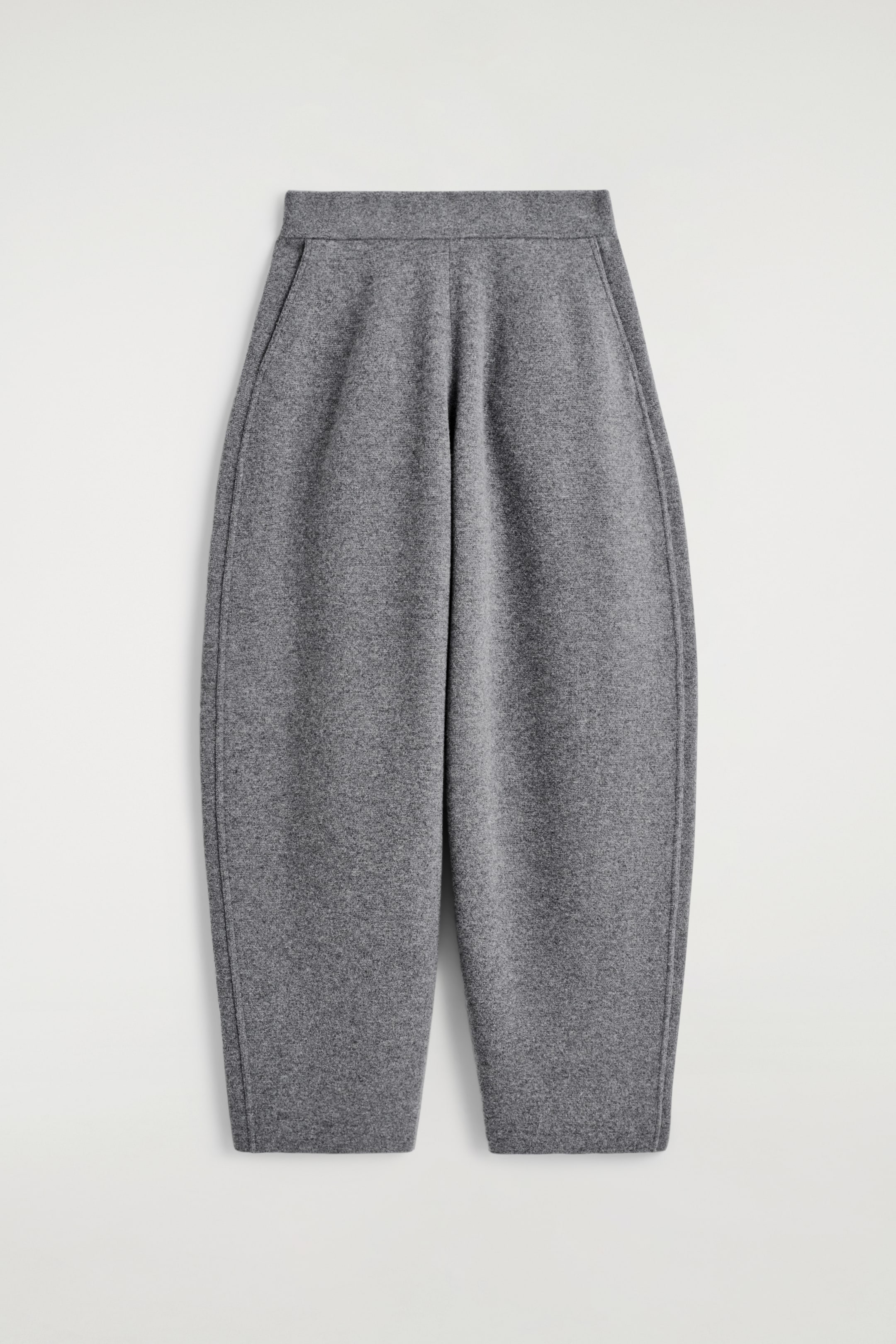 Grösseres Bild ansehen: Holzkohlegraue Strickhosen werden von vorne gezeigt und haben eine Fassform, einen flachen Bund und schräge Seitentaschen.