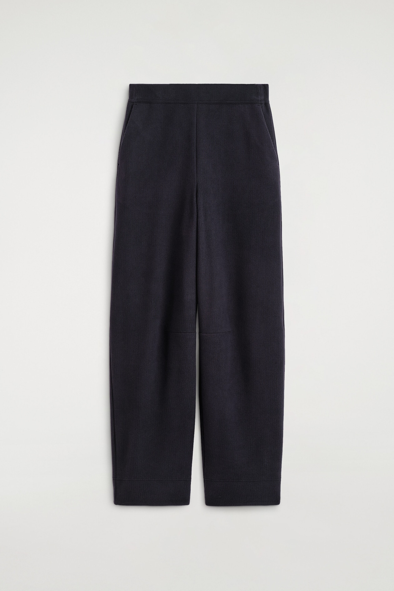 These corduroy-jersey wide-leg pants are shown from the front, featuring a deep navy tone and a ribbed, textured finish. The design includes a flat waistband, side slit pockets, horizontal seam details at the knees, and a relaxed, slightly tapered leg shape.