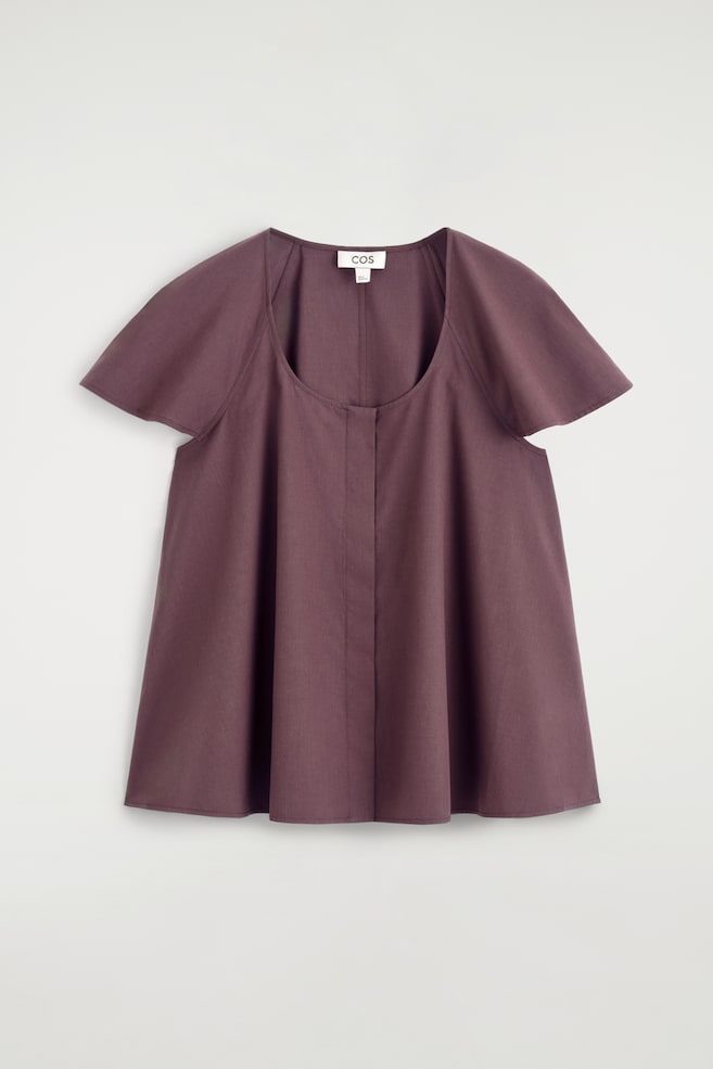 Une blouse violette foncée est présentée de face, avec un col rond, des manches courtes évasées, et une silhouette trapèze ample avec une couture centrale à l'avant. - 1