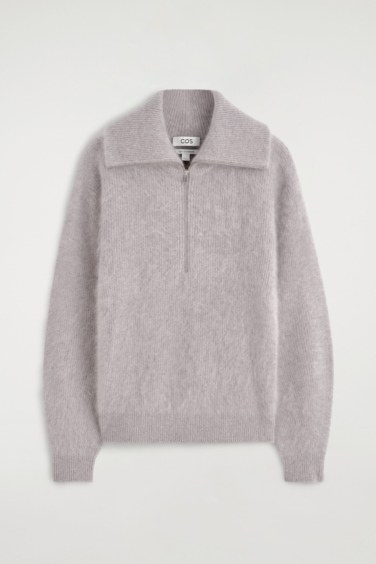 A light gray cashmere sweater is shown from the front, featuring a brushed, fuzzy texture and a vertical ribbed knit pattern. The sweater includes a silver-tone half-zip at the collar, long sleeves with ribbed cuffs, and a matching ribbed hem.