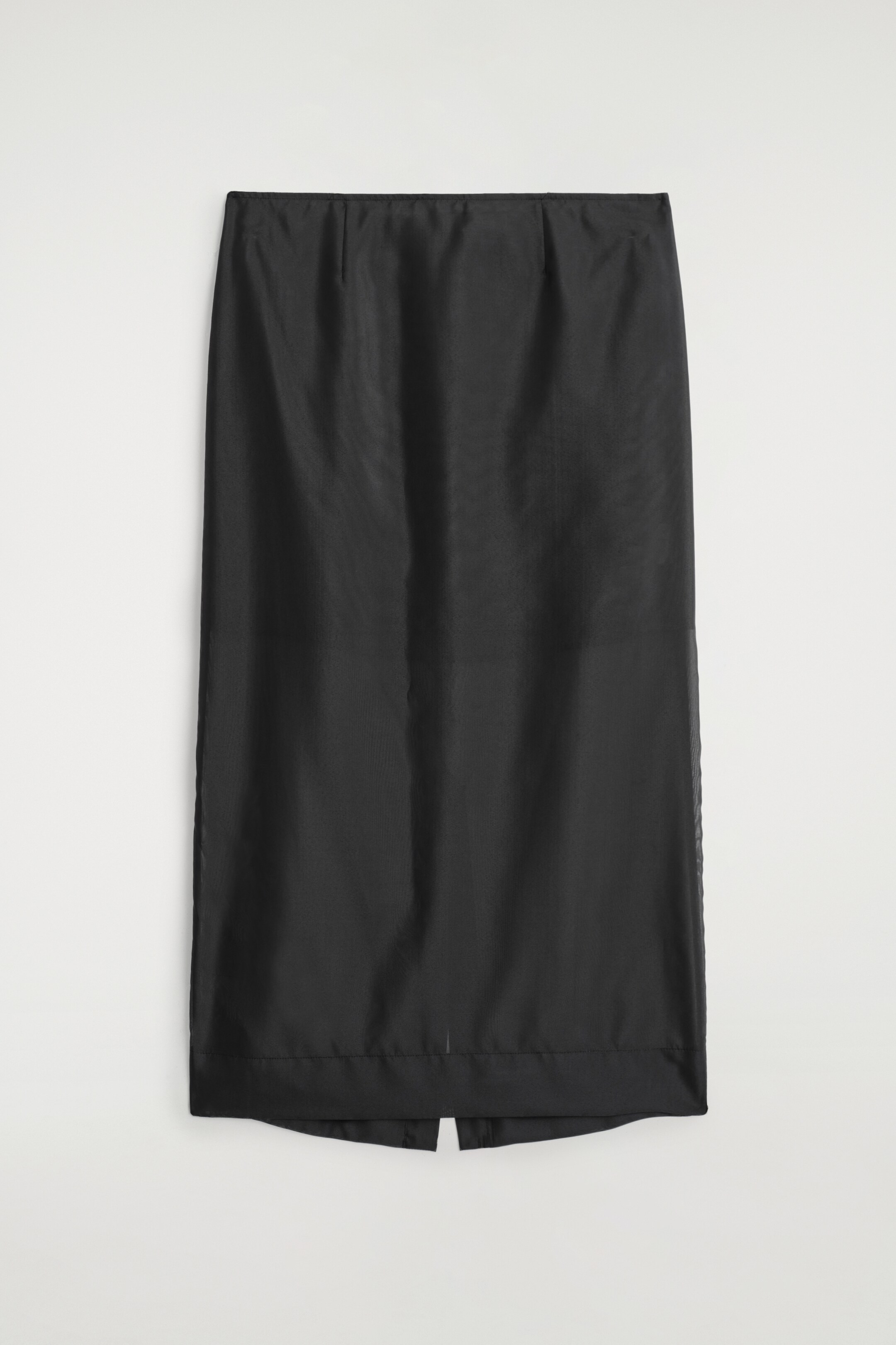 View larger image: A black column skirt is presented flat, facing FRONT, featuring a sheer, gauzy outer layer over a more opaque internal layer, which is creating a layered effect and a straight, midi-length silhouette.