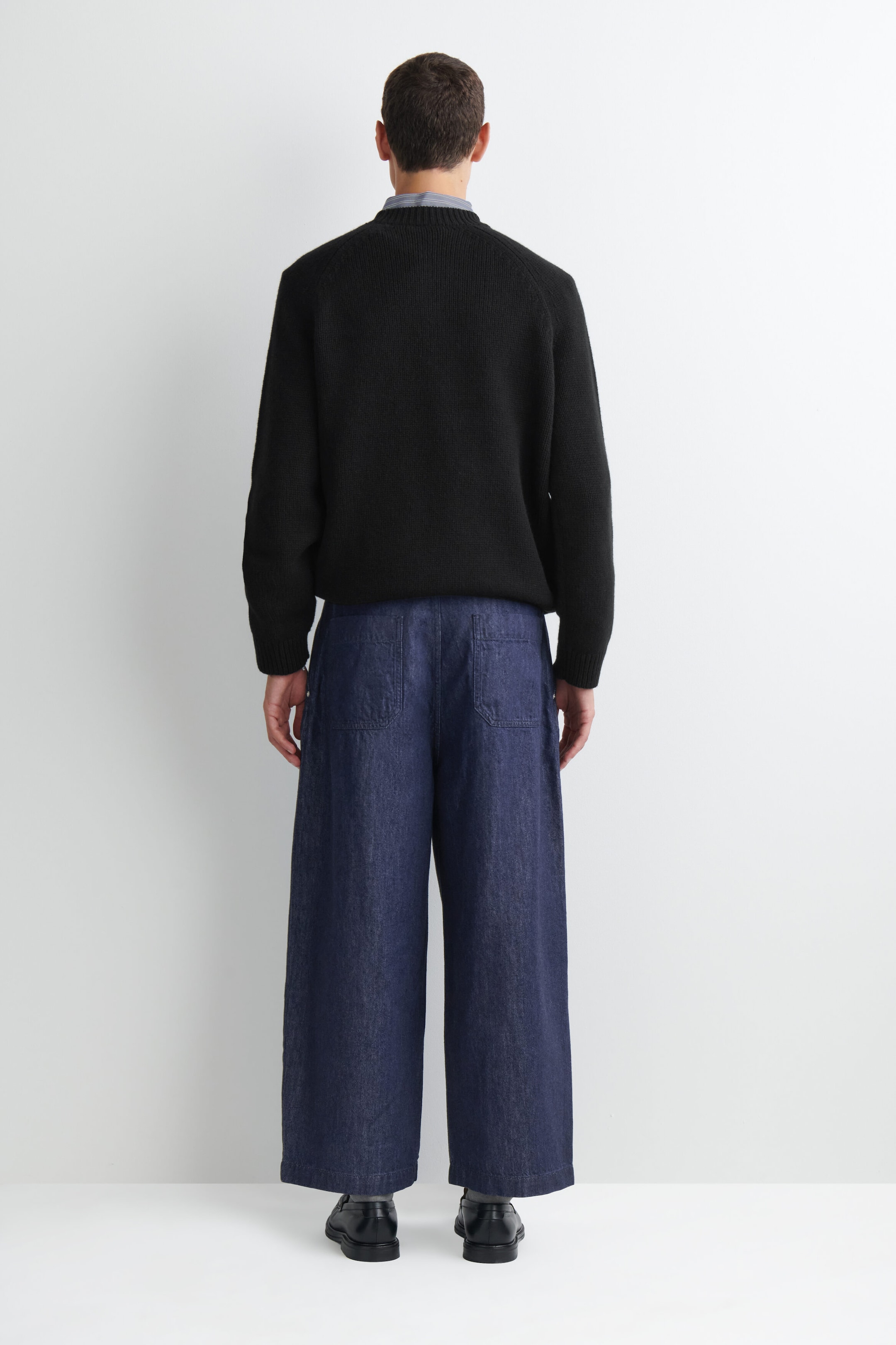 Ce pantalon en denim plissé à coupe décontractée et jambe ballon est présenté de dos, mettant en valeur un délavage bleu profond et une silhouette large et arrondie. Il comporte deux grandes poches plaquées à l’arrière et tombe à une longueur décontractée frôlant la cheville. Ce pantalon en denim plissé à coupe décontractée et jambe ballon est présenté de dos, mettant en valeur un délavage bleu profond et une silhouette large et arrondie. Il comporte deux grandes poches plaquées à l’arrière et tombe à une longueur décontractée frôlant la cheville.