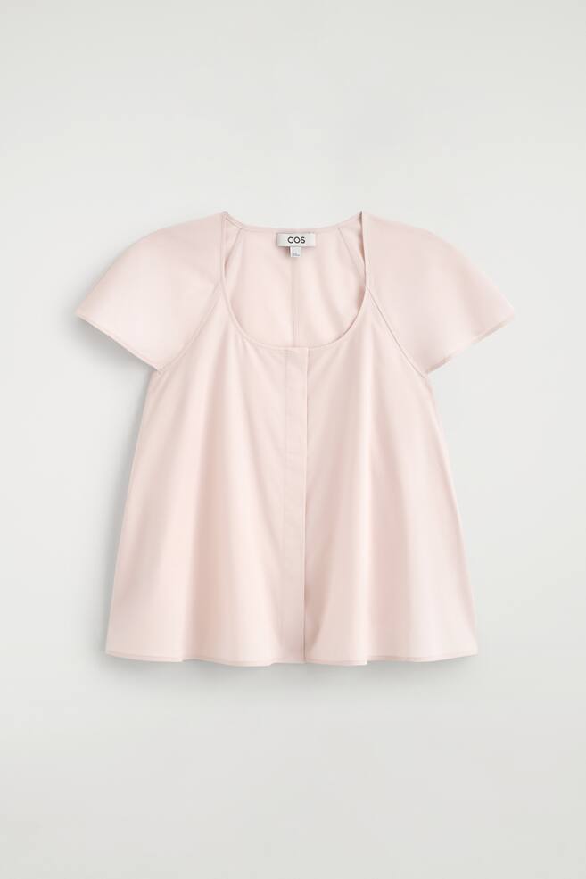 La blouse rose pâle est présentée de face, avec un col rond, des manches courtes évasées et une couture verticale centrale à l'avant. - 1