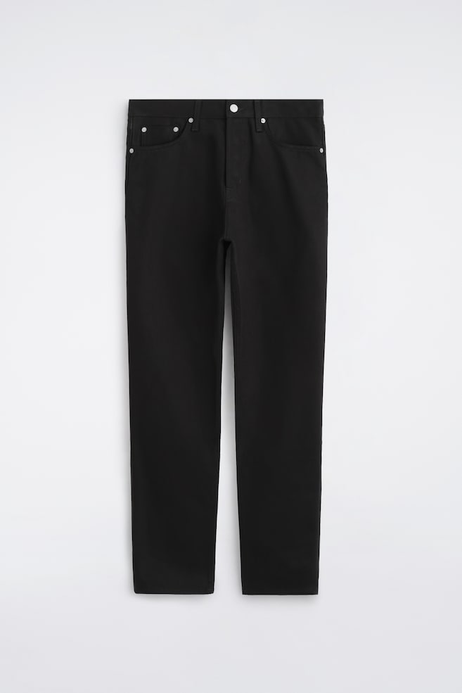 Die Signature Regular-Fit Straight-Leg Jeans sind in einer frontalen Ansicht dargestellt und zeigen einen einfarbig schwarzen Stoff mit klassischem Five-Pocket-Design. Sie verfügen über eine Straight-Leg-Silhouette, einen Bund mit Gürtelschlaufen und einen mittigen Frontknopfverschluss mit silberfarbenen Metallnieten. - 1