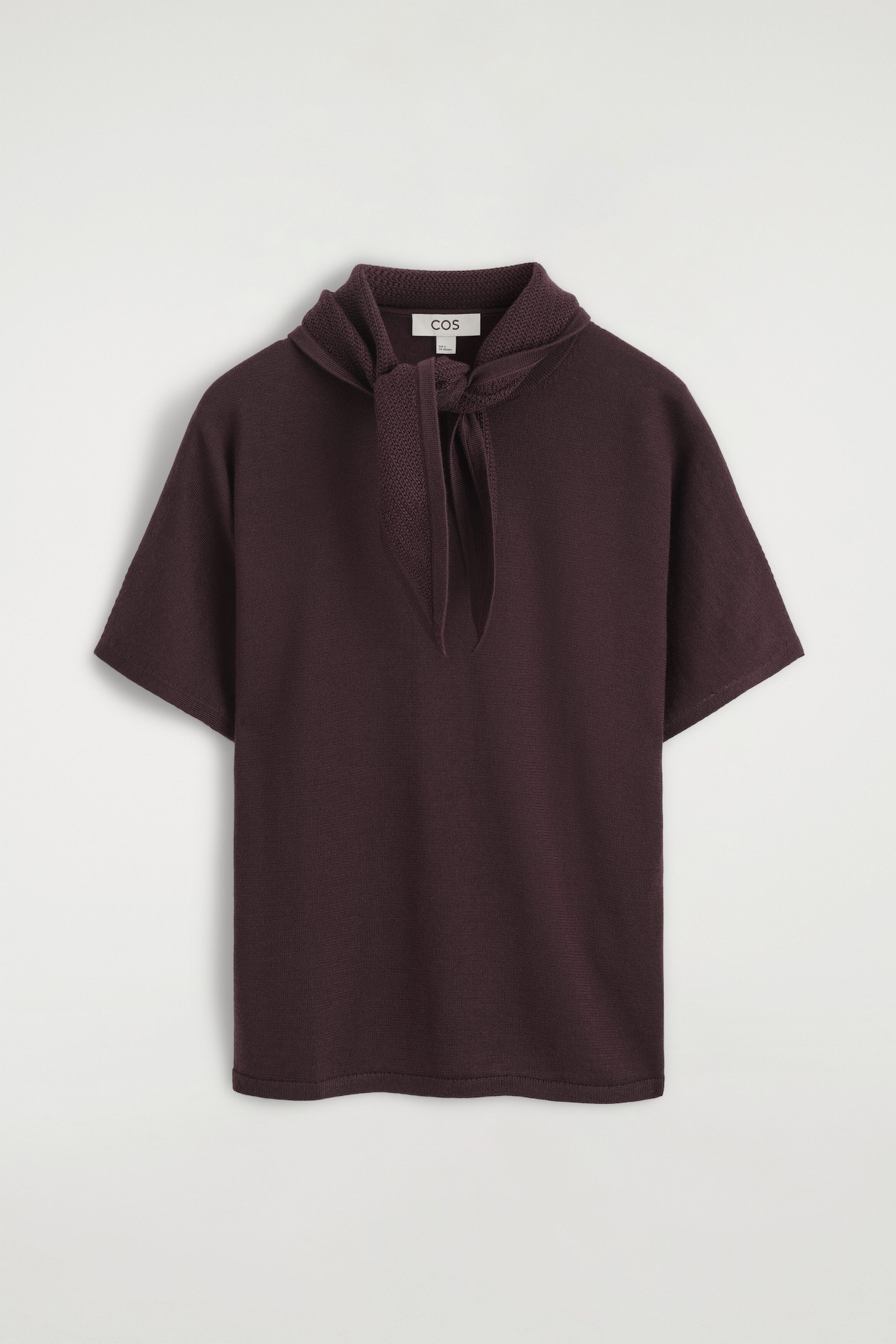 The front view of the scarf-detail merino wool blend T-shirt is shown in a deep plum color, featuring short sleeves and a fine-knit texture. An integrated textured-knit scarf detail wraps around the collar and ties in a loose knot at the center neck.