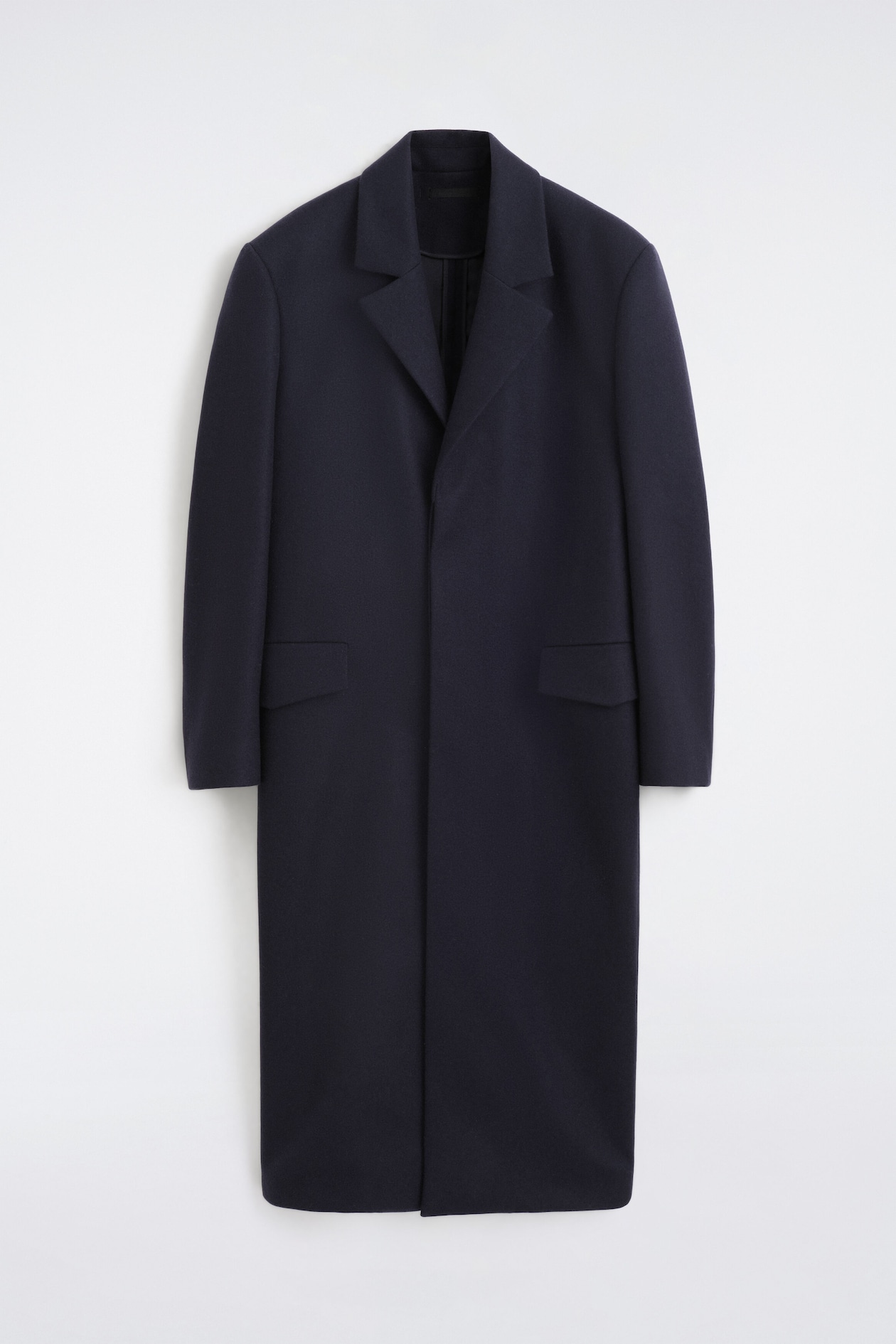 A dark blue coat is shown from the front, featuring notch lapels and two flap pockets. It has a straight silhouette and falls below the knees.