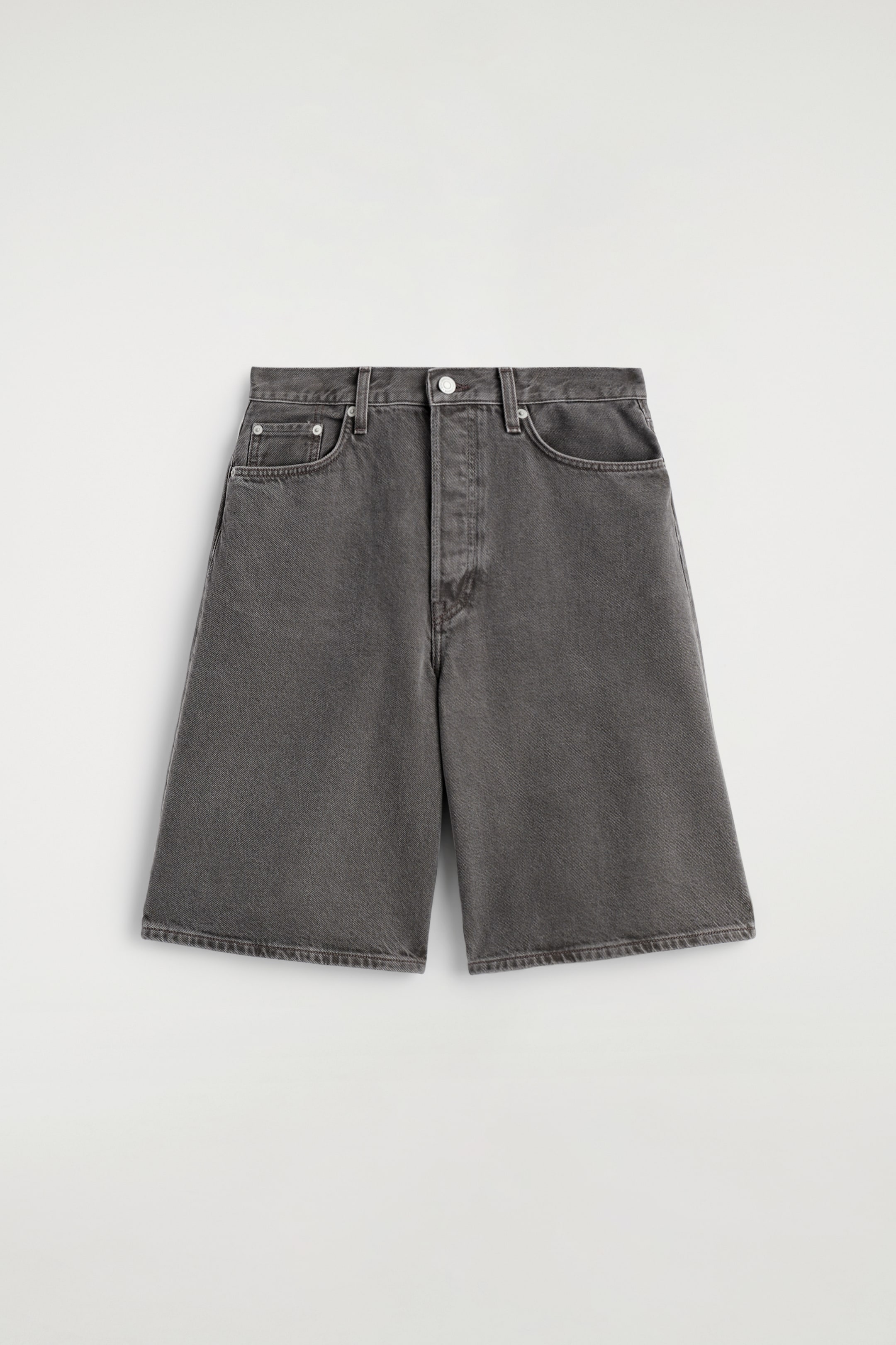 Visa större bild: Ett par långlinje, högmidjade denimshorts presenteras FRAM, med en tvättad espressonyans och tonala sömmar. De har en knapp- och dragkedjestängning och en femficksdesign med synliga fram- och myntfickor.