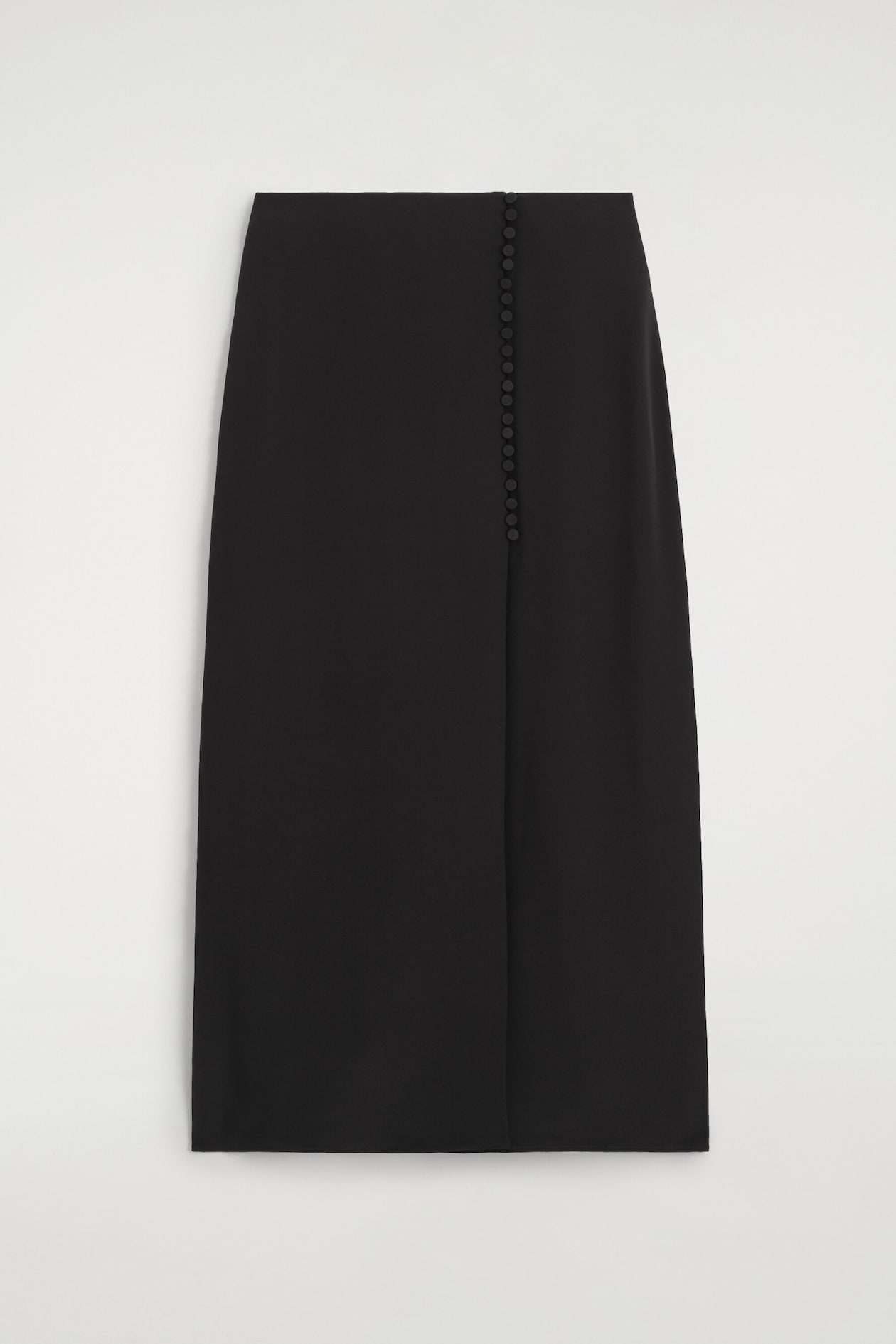 A black midi skirt is shown front-facing, featuring a high-waisted, straight silhouette. The skirt displays a vertical row of small, fabric-covered buttons running down the left front side from the waistband.