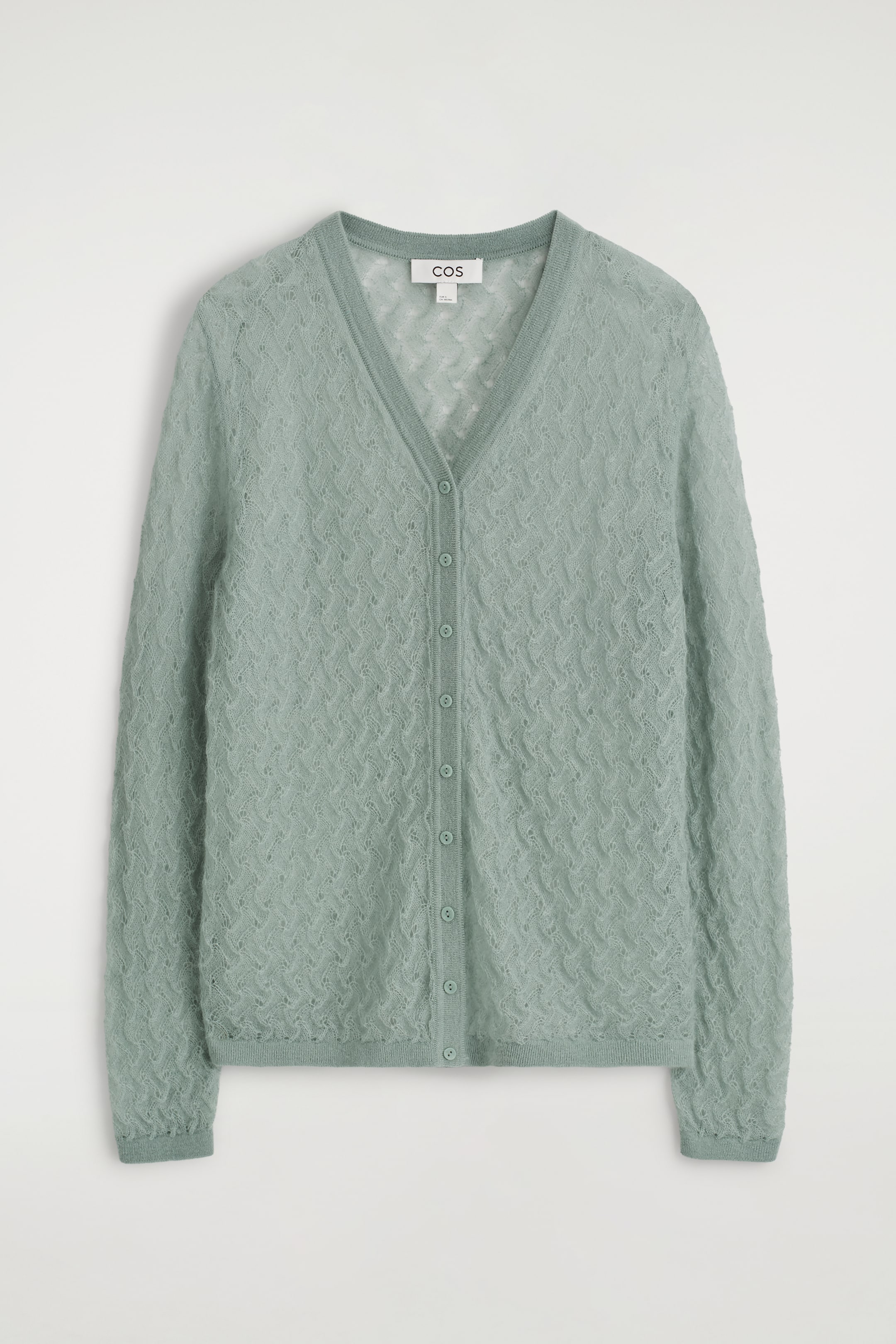 Grösseres Bild ansehen: Ein hellgrüner V-Ausschnitt-Cardigan wird von vorne gezeigt. Er zeichnet sich durch ein zartes Pointelle-Strickmuster in seinem dezent durchsichtigen Stoff aus, mit einer Reihe passender Knöpfe, die die Vorderseite schließen, und gerippten Bündchen und Saum, die das Kleidungsstück abrunden.