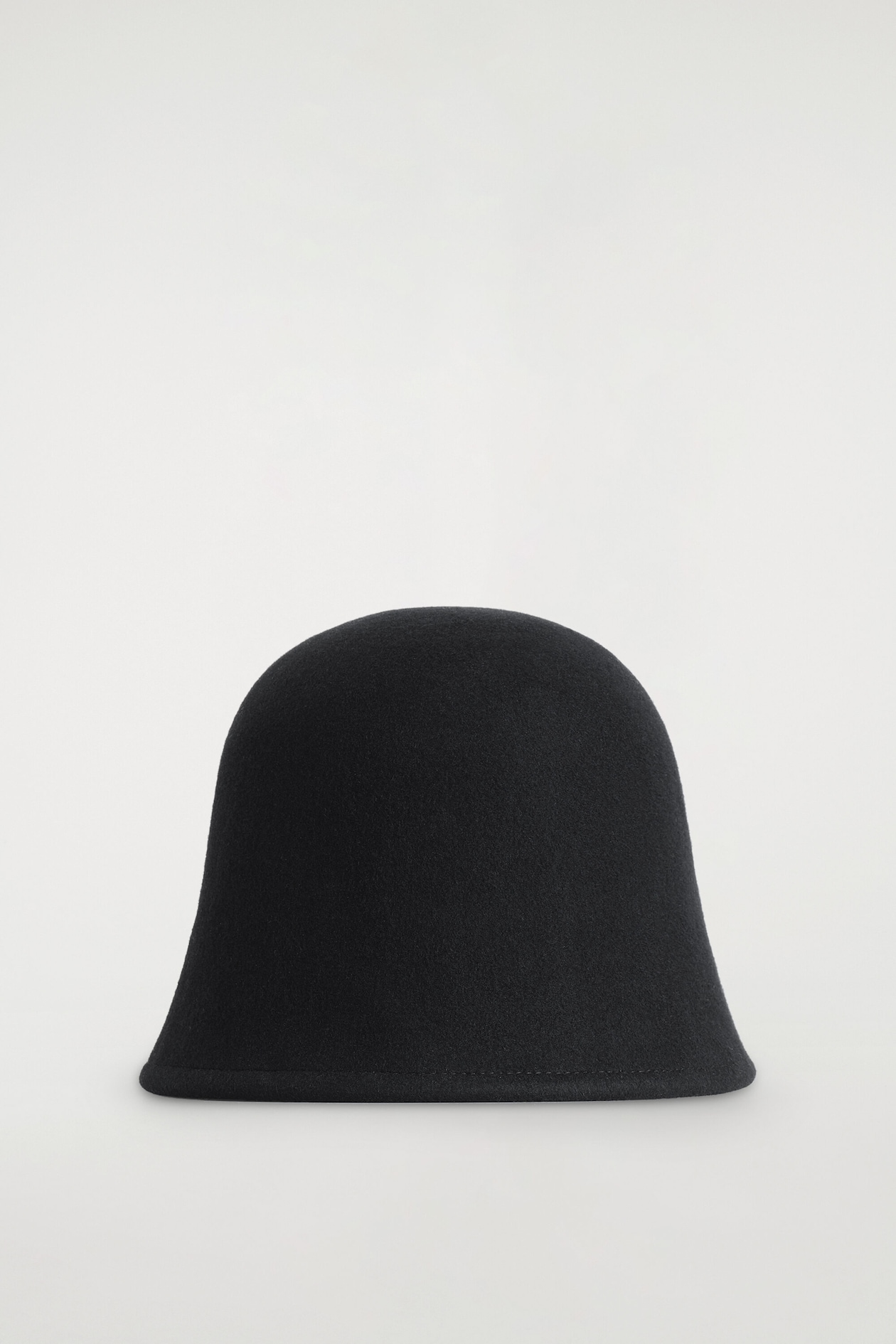 A black boiled wool bucket hat is shown from the front, featuring a softly sculpted dome crown and a gently flared brim with a subtly rolled edge.
