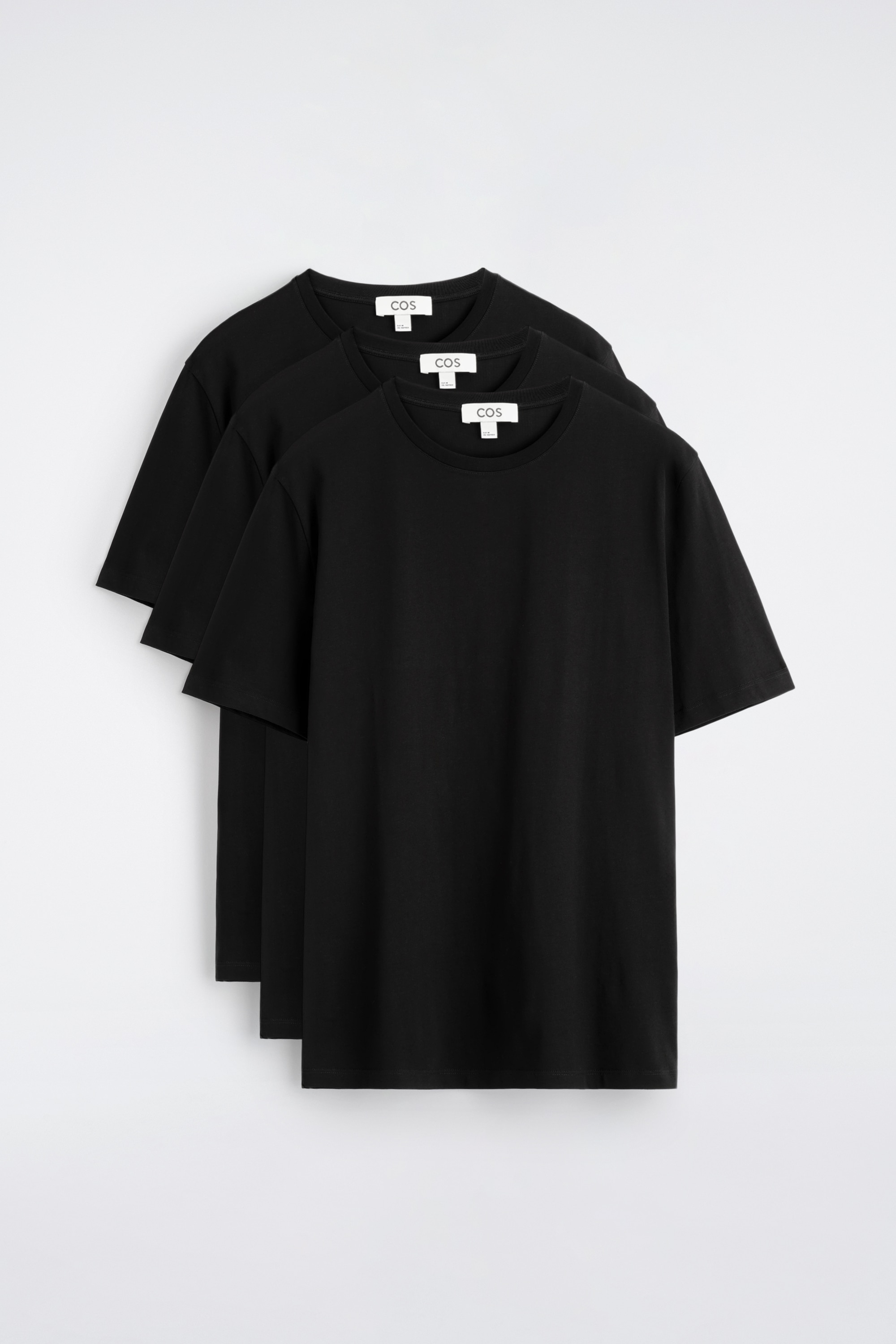 Un t-shirt noir à col rond est présenté de face, avec des manches courtes et une silhouette lisse, légèrement ajustée.