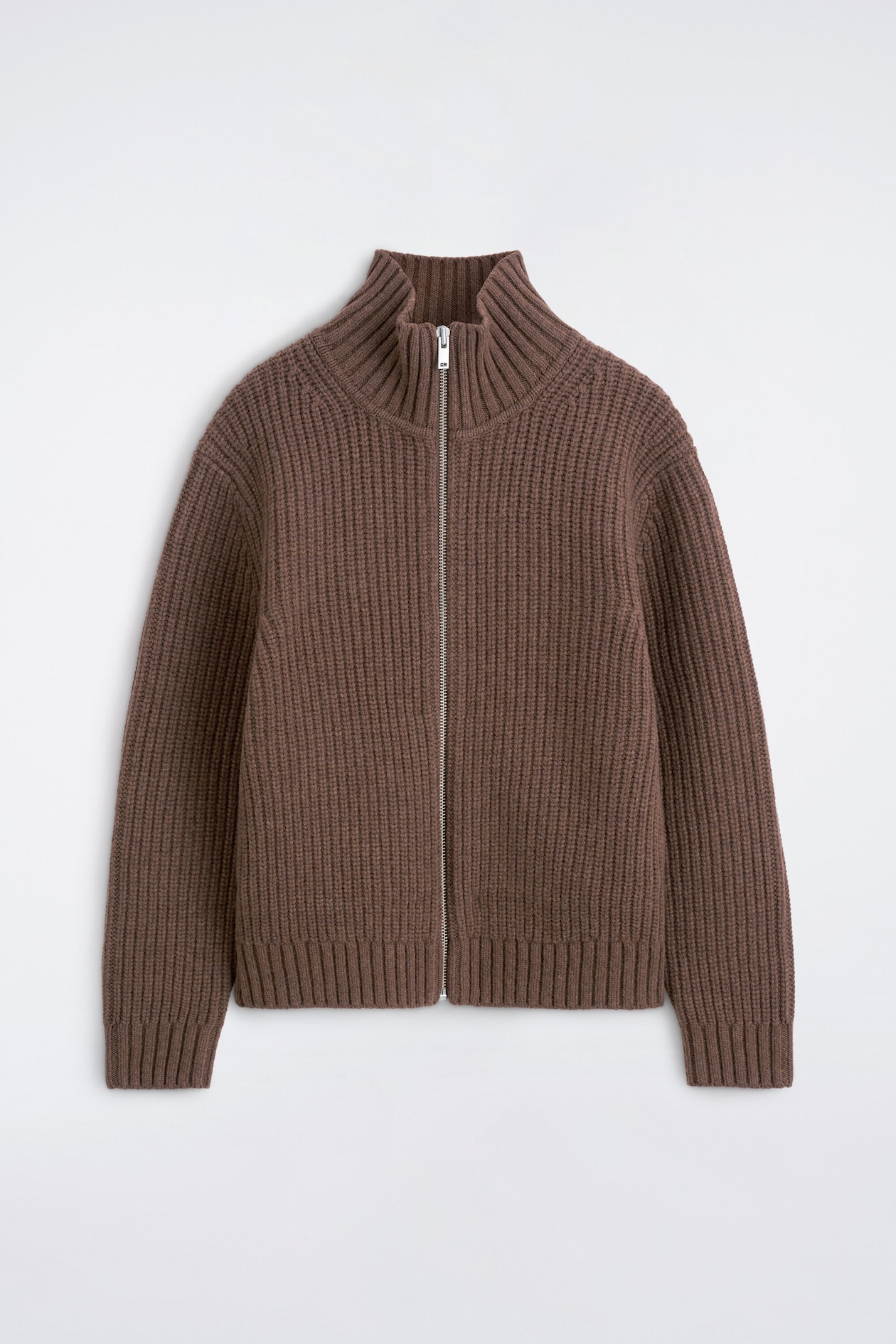A brown ribbed-knit cardigan is shown in a front view, featuring a full-length silver-tone zipper closure that extends to a high mock neck. The garment displays a chunky ribbed texture with defined ribbing on the collar, cuffs, and hem.