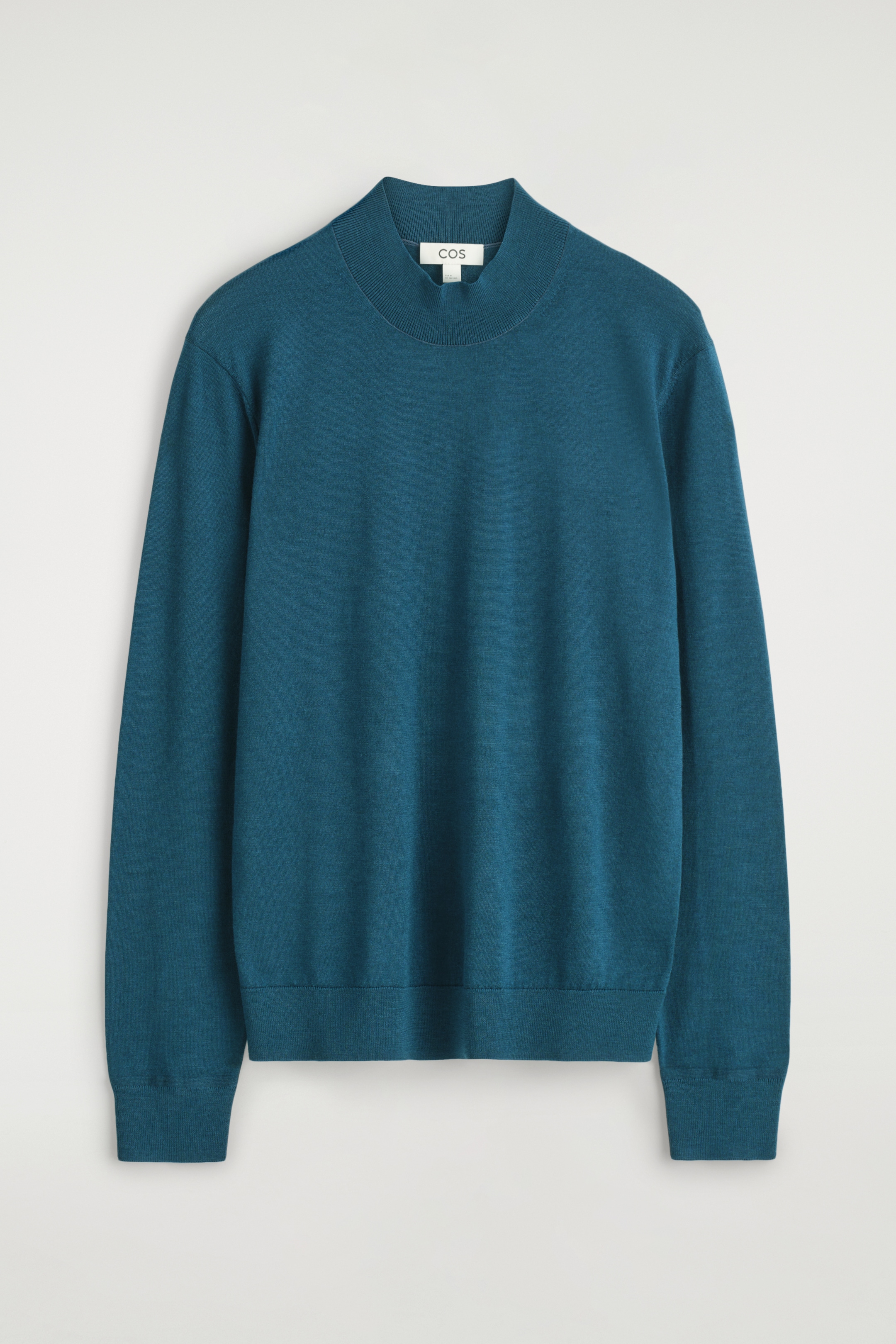 View larger image: A teal merino wool jumper is being presented from the FRONT, featuring a smooth knit texture. It is designed with a ribbed mock neck, long sleeves with ribbed cuffs, and a ribbed hem.