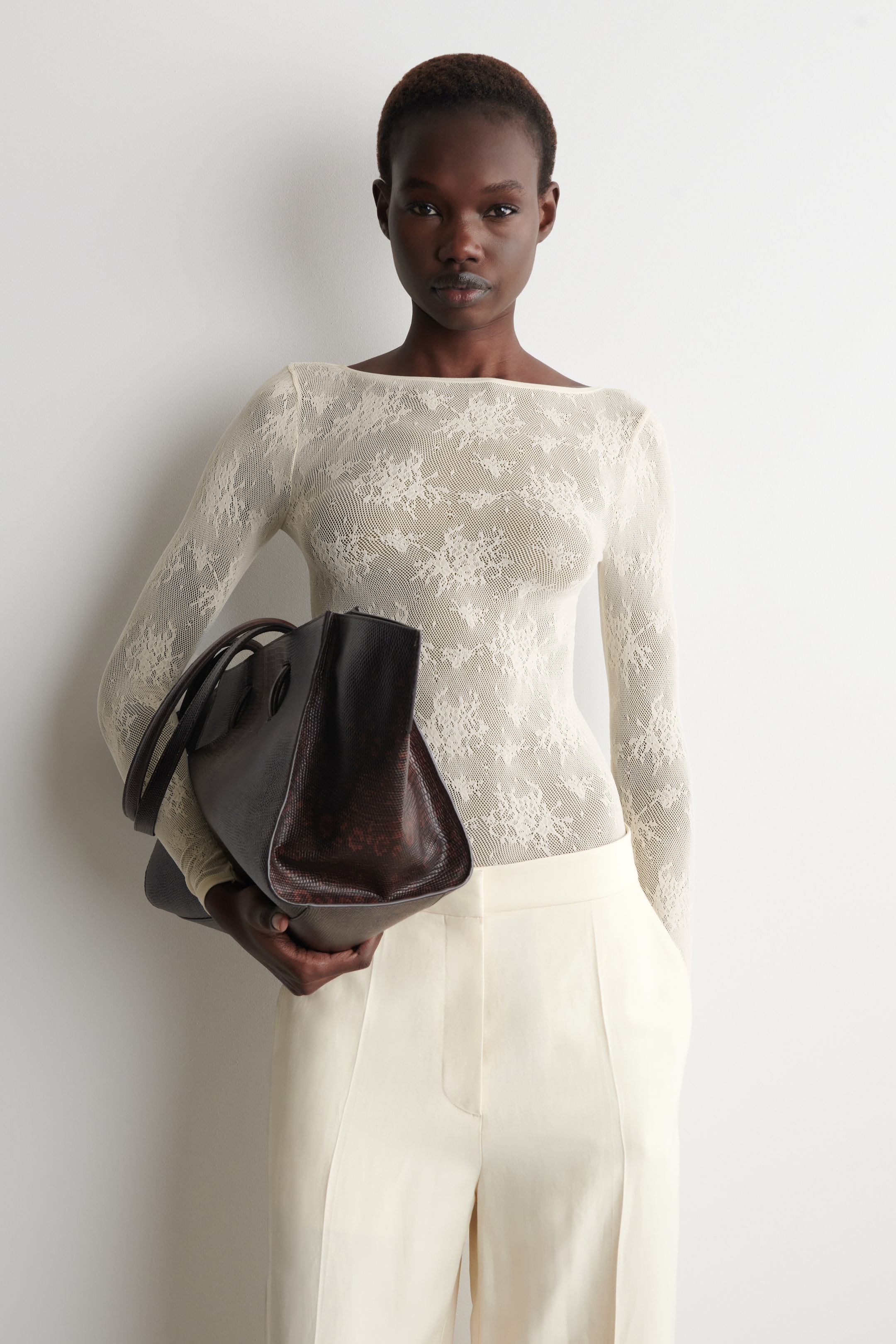 View larger image: The long-sleeved top is showcased from the front, featuring a boat neckline and a slim fit, crafted from off-white floral-jacquard lace.