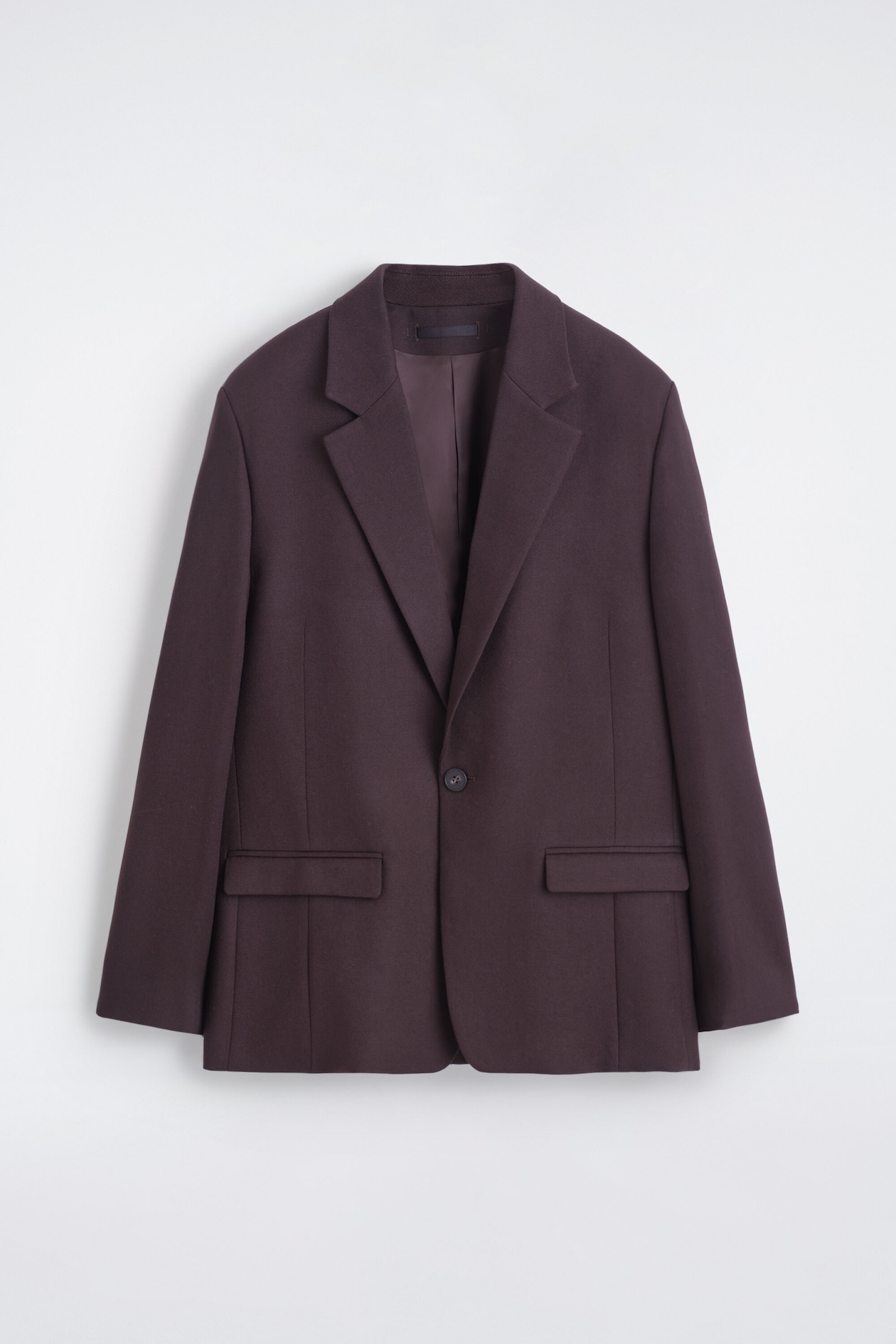 A dark plum blazer is shown from the front, featuring notch lapels and a single-button fastening. Two flap pockets are visible on the lower front.