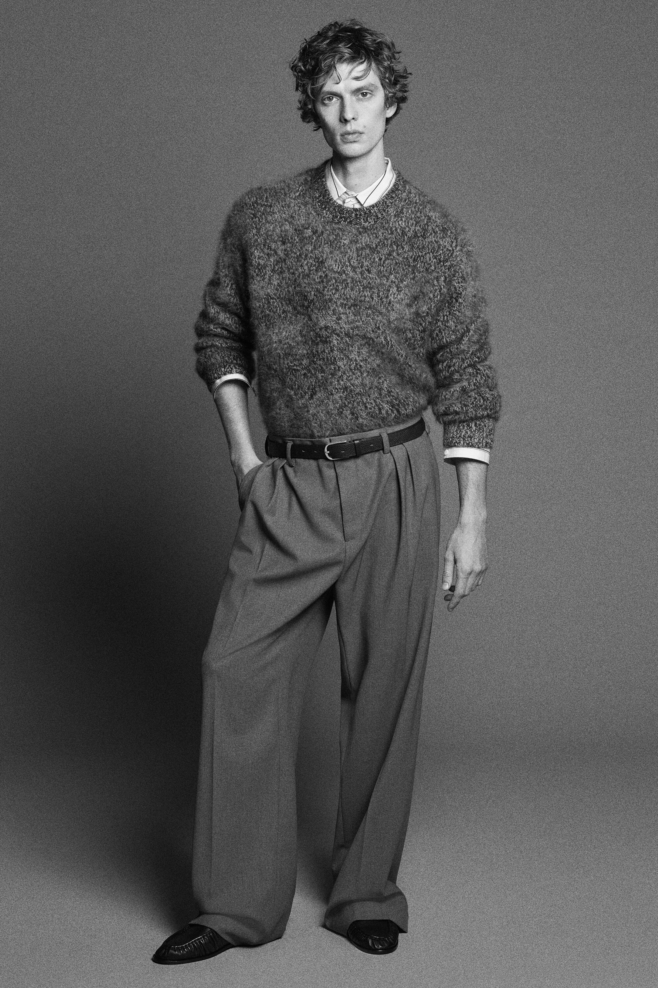 The two-tone brushed-cashmere crew-neck jumper is shown from the front, showcasing a fuzzy, heavily brushed texture and a relaxed fit. It is being worn layered over a collared shirt and tucked into wide-leg trousers, with its ribbed cuffs pushed up slightly. The two-tone brushed-cashmere crew-neck jumper is shown from the front, showcasing a fuzzy, heavily brushed texture and a relaxed fit. It is being worn layered over a collared shirt and tucked into wide-leg trousers, with its ribbed cuffs pushed up slightly.